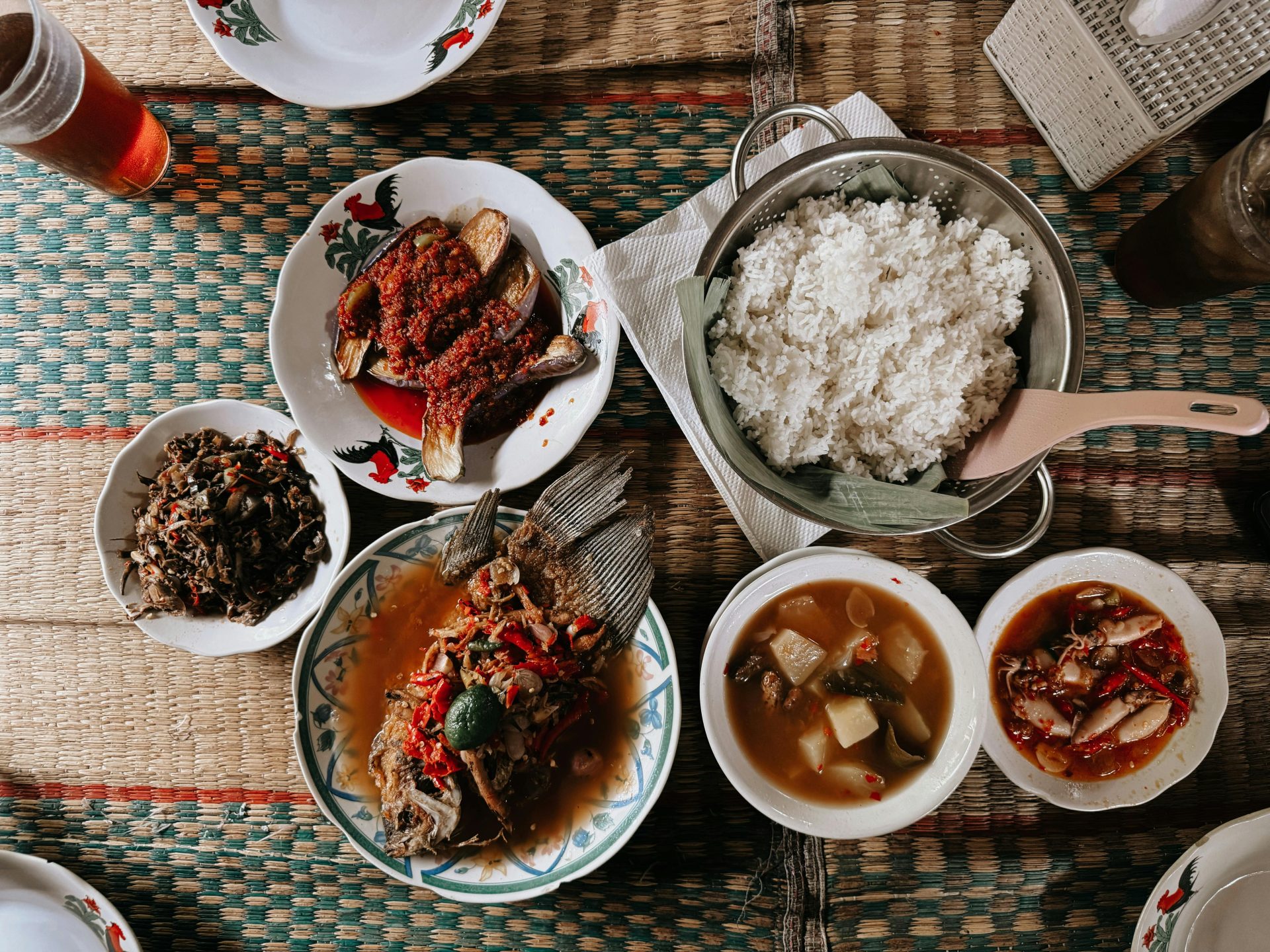 An overhead view of Indonesian dishes in small bowls around rice