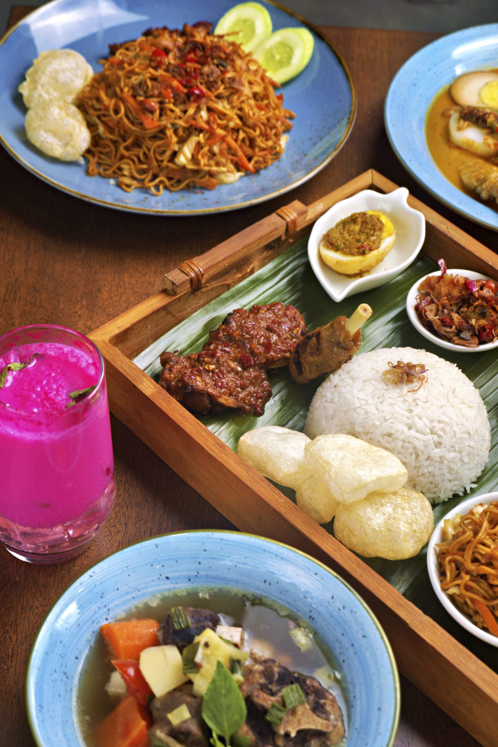 A tray of rice, fried sides and a cold drink
