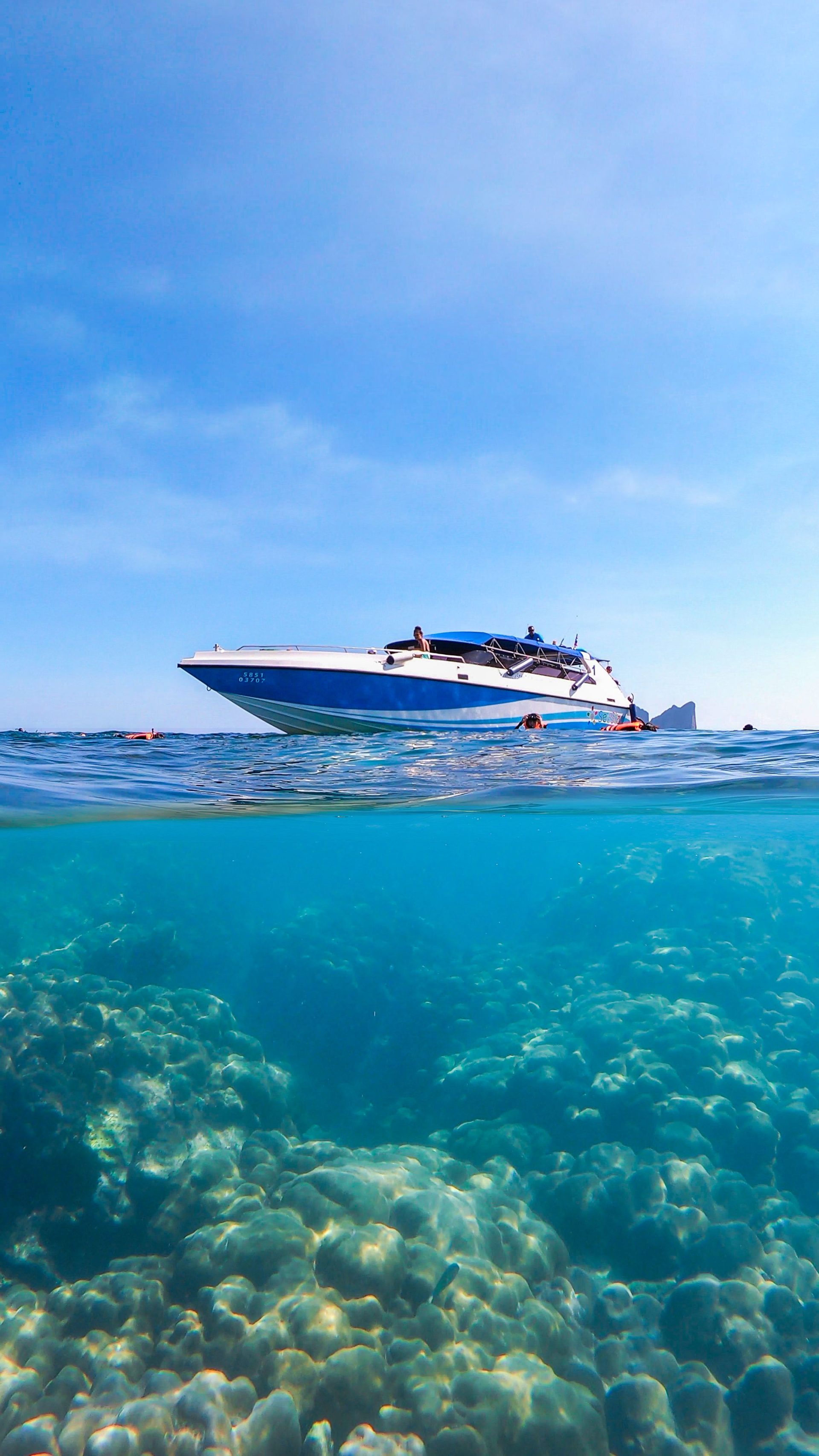A speedboat crossing clear shallow water
