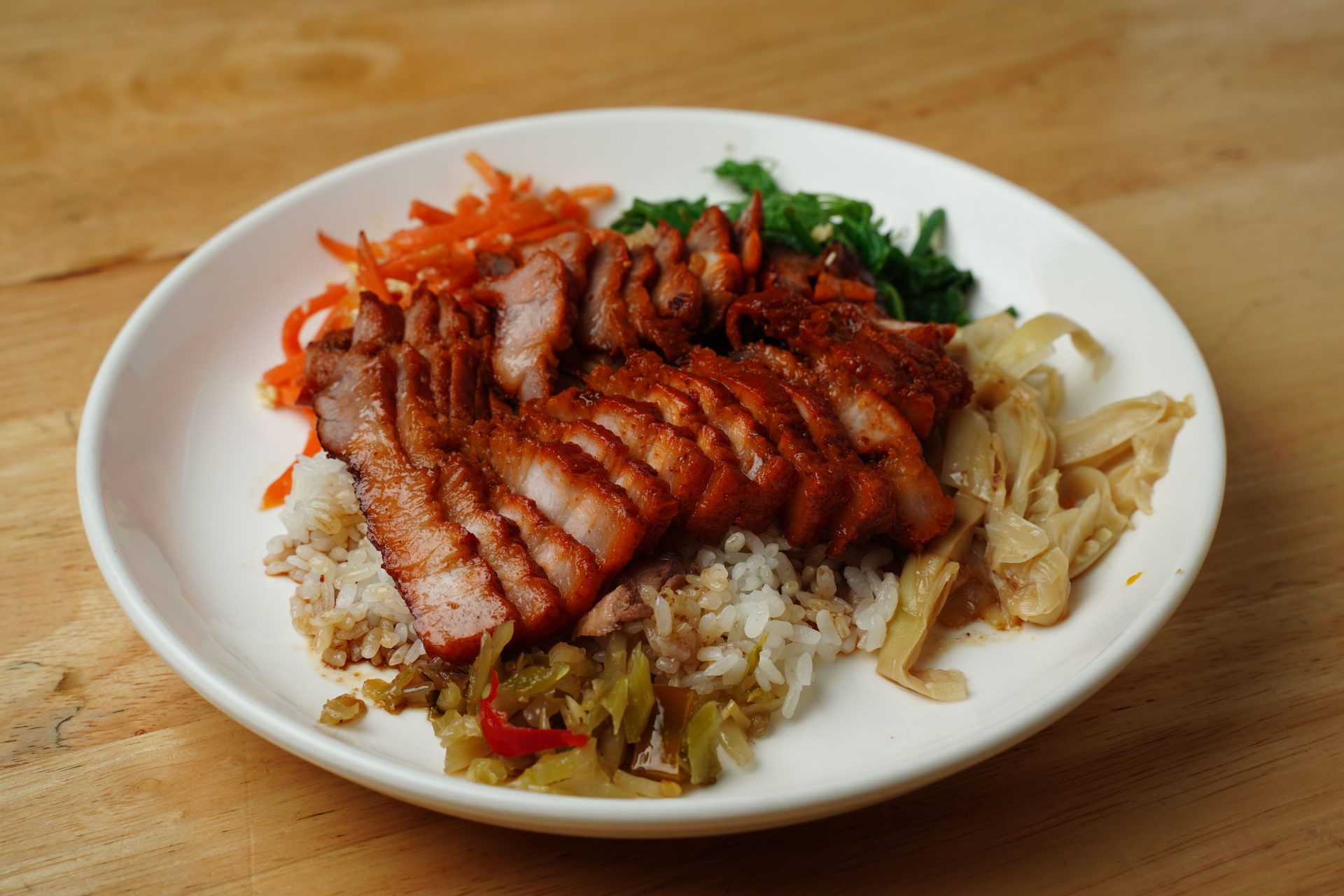 A grilled pork rice bowl with pickled vegetables