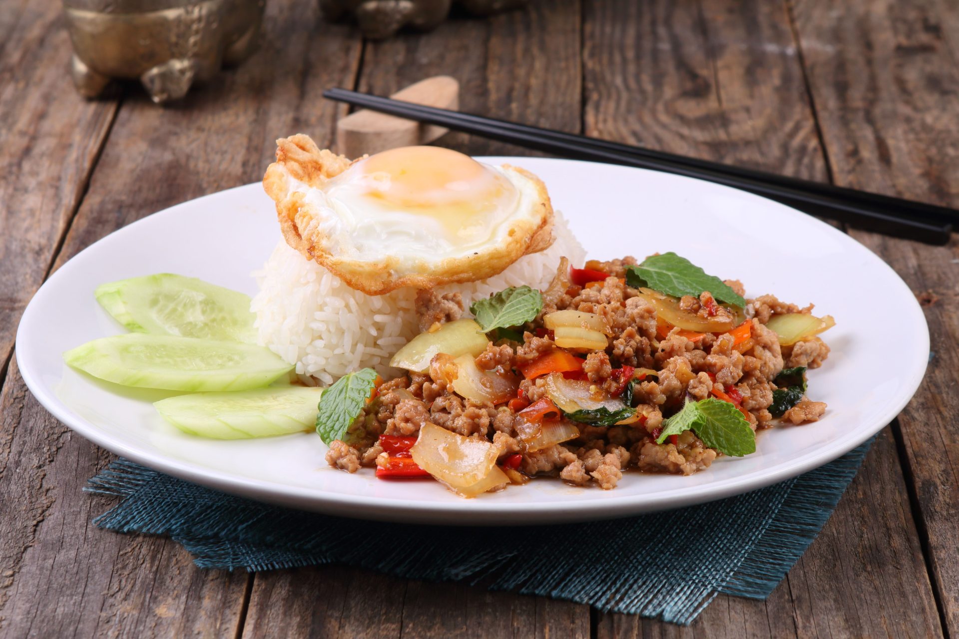 A plate of Thai basil pork with rice and a fried egg