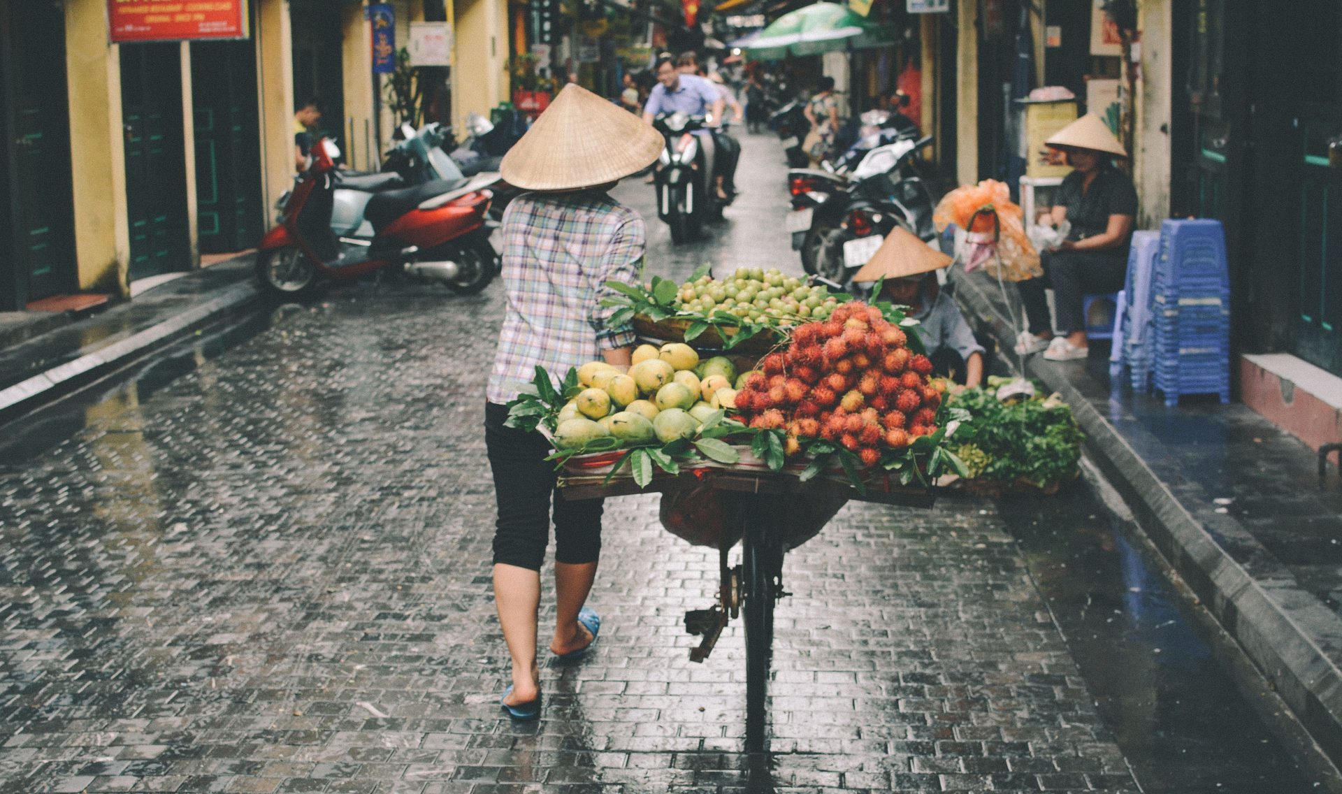 Vendors in conical hats selling produce from boats at a floating market