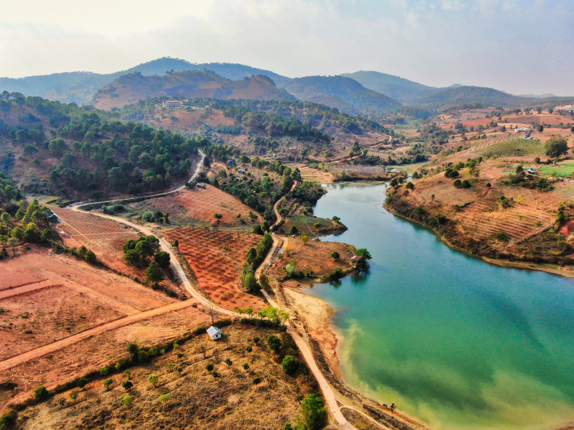 A stunning aerial view of farmland and hills in Shan State, Myanmar, showcasing natural beauty and vibrant landscapes.