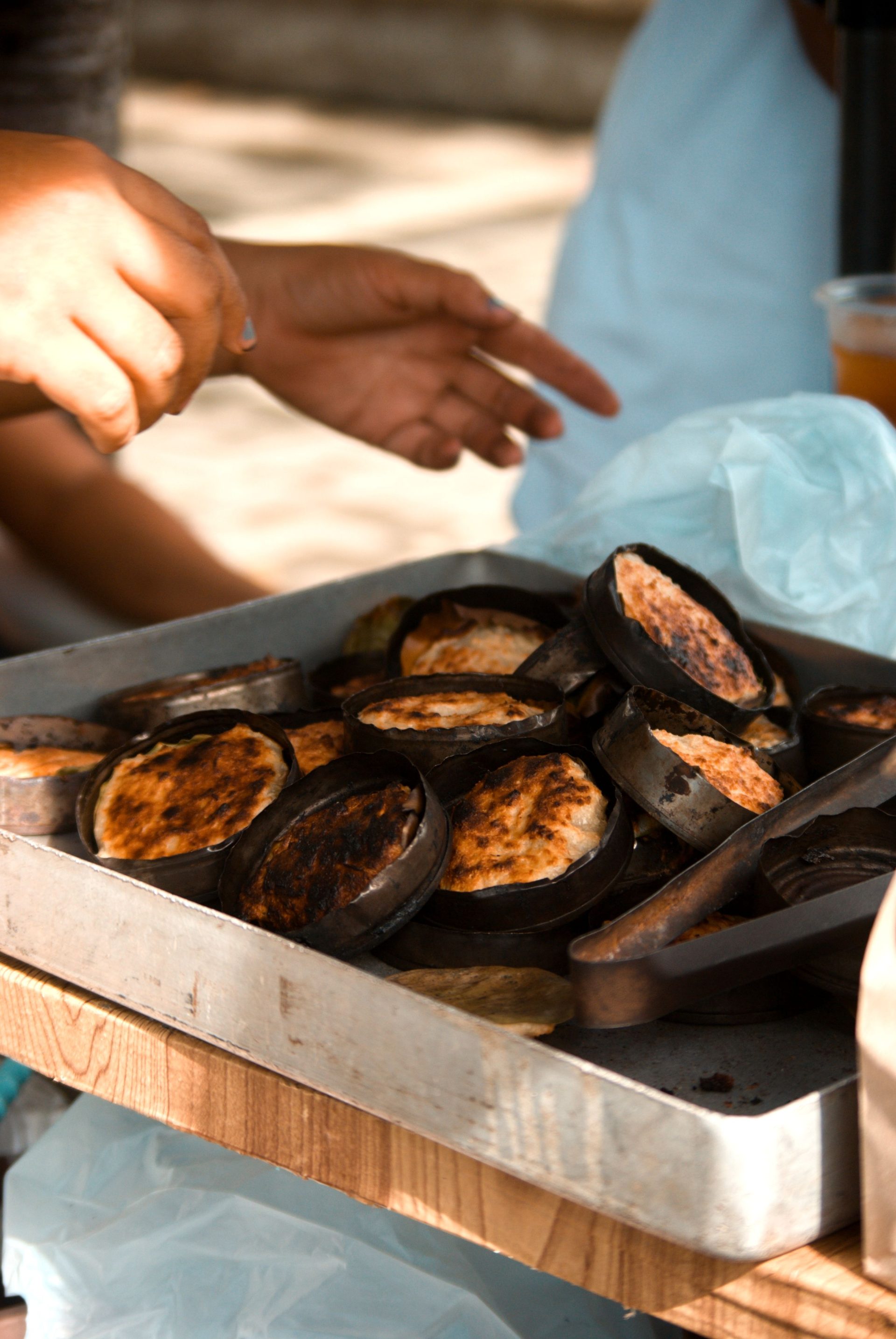 Vendor cooking khanom khrok coconut pancakes street-side