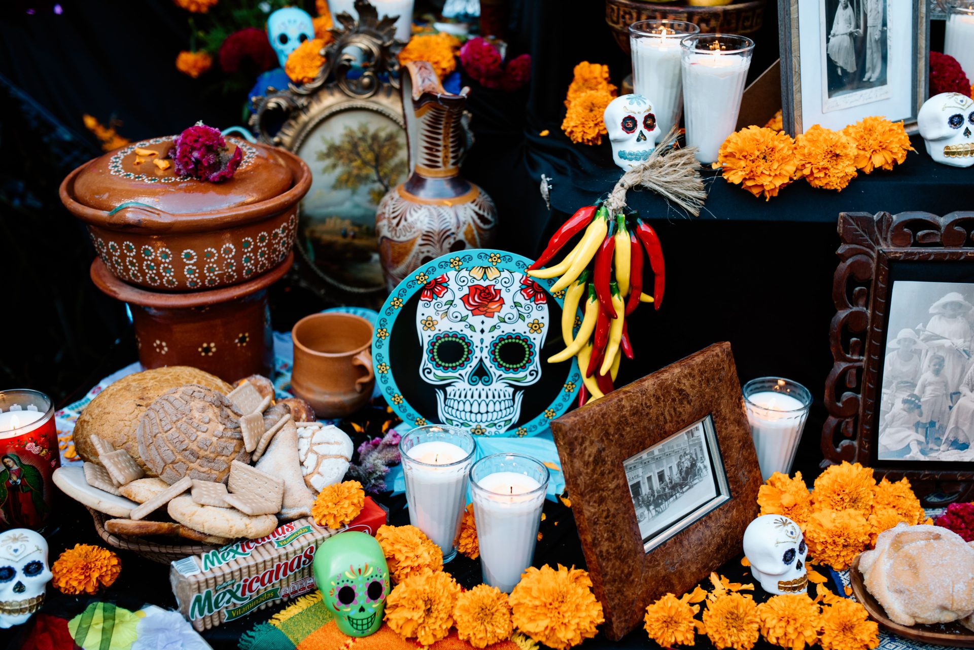 A Dia de Muertos altar with sugar skulls, candles and marigolds