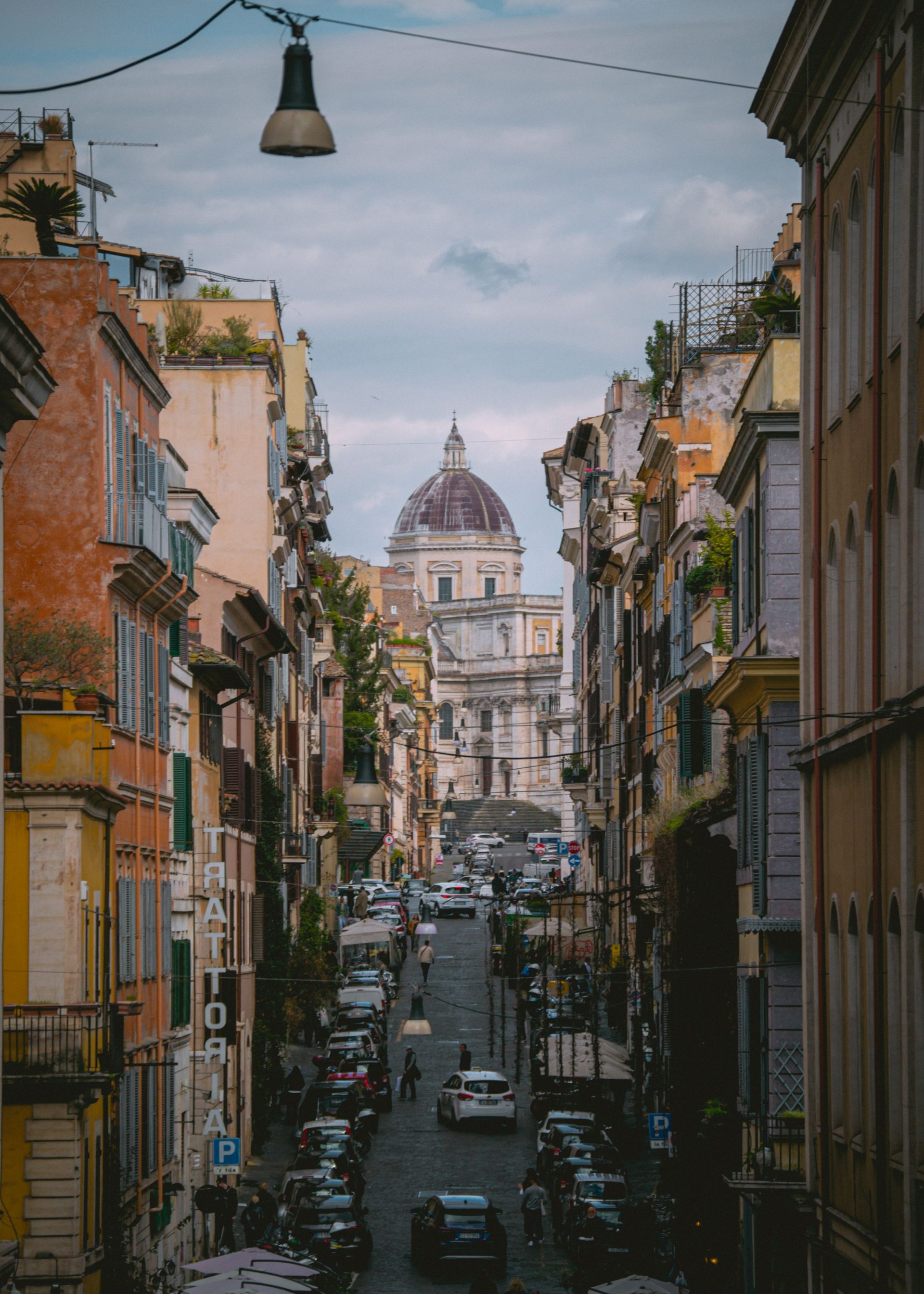 A long straight Roman street running towards a domed building