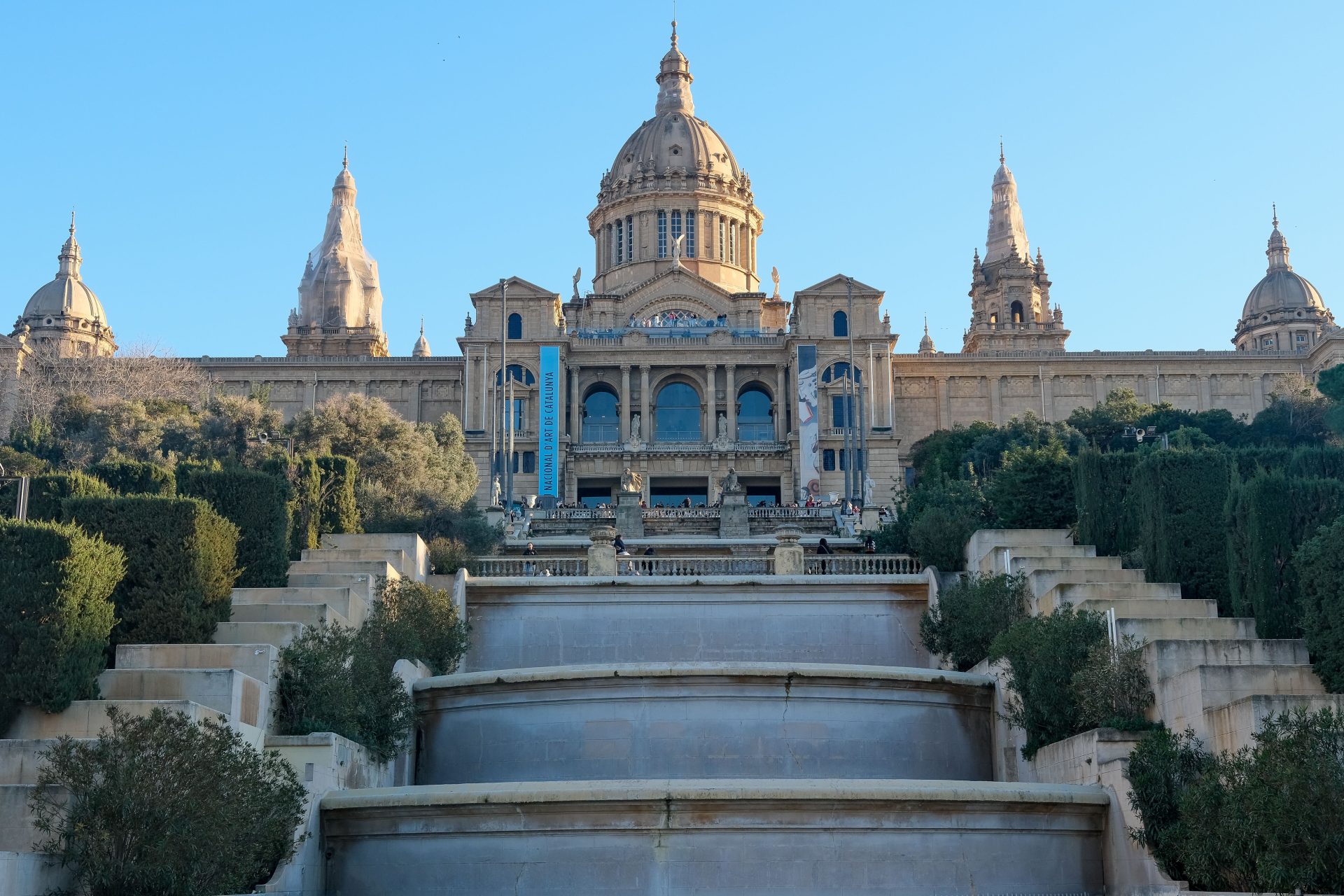 A grand museum building above terraced steps on Montjuic hill