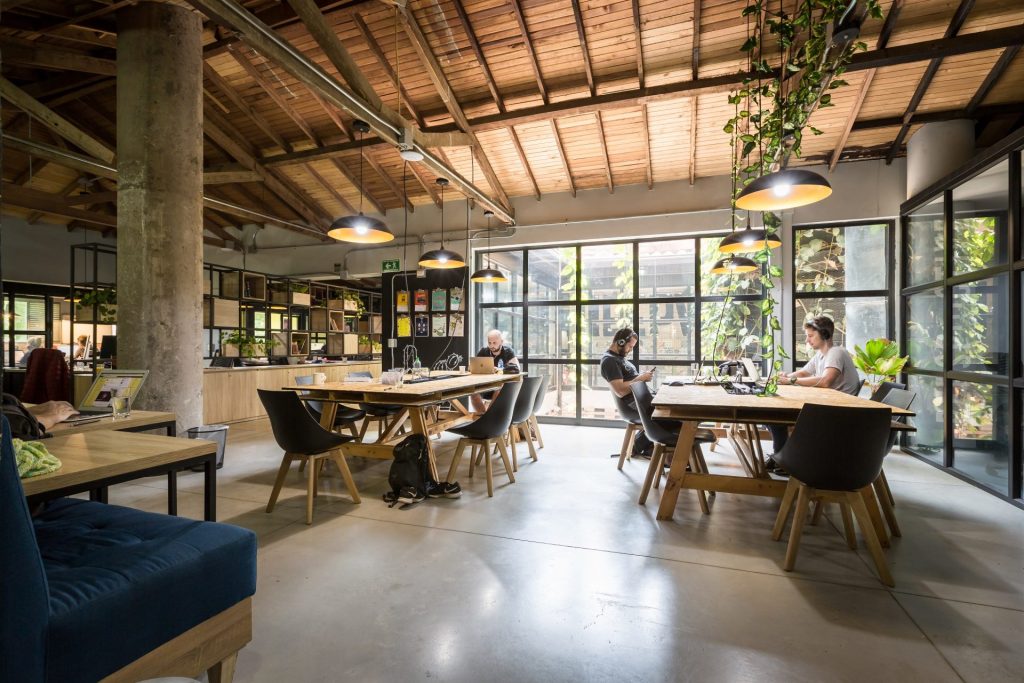 A bright modern coworking space in Medellín with shared tables and plants