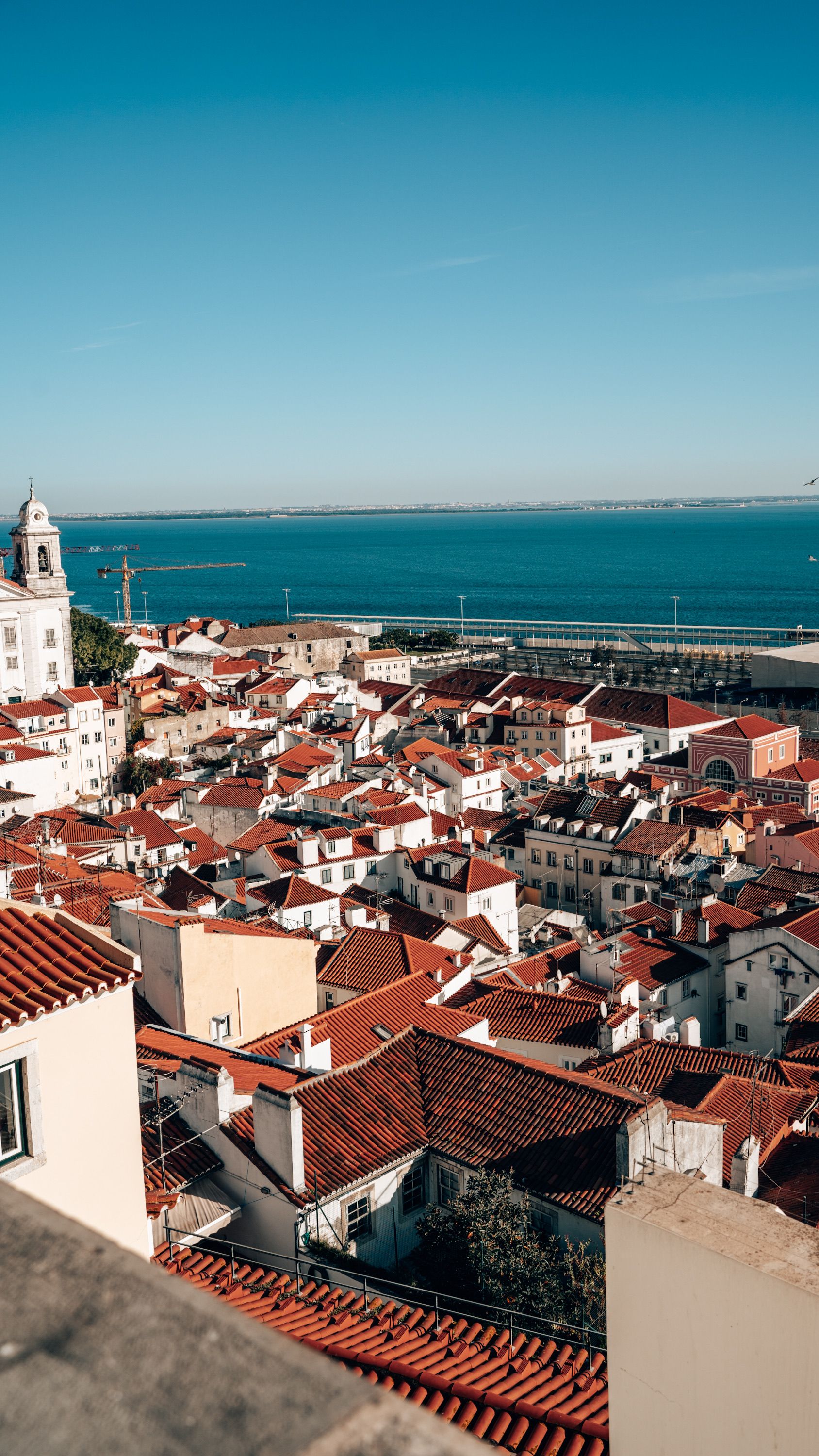 Alfama rooftops stepping down to the Tagus