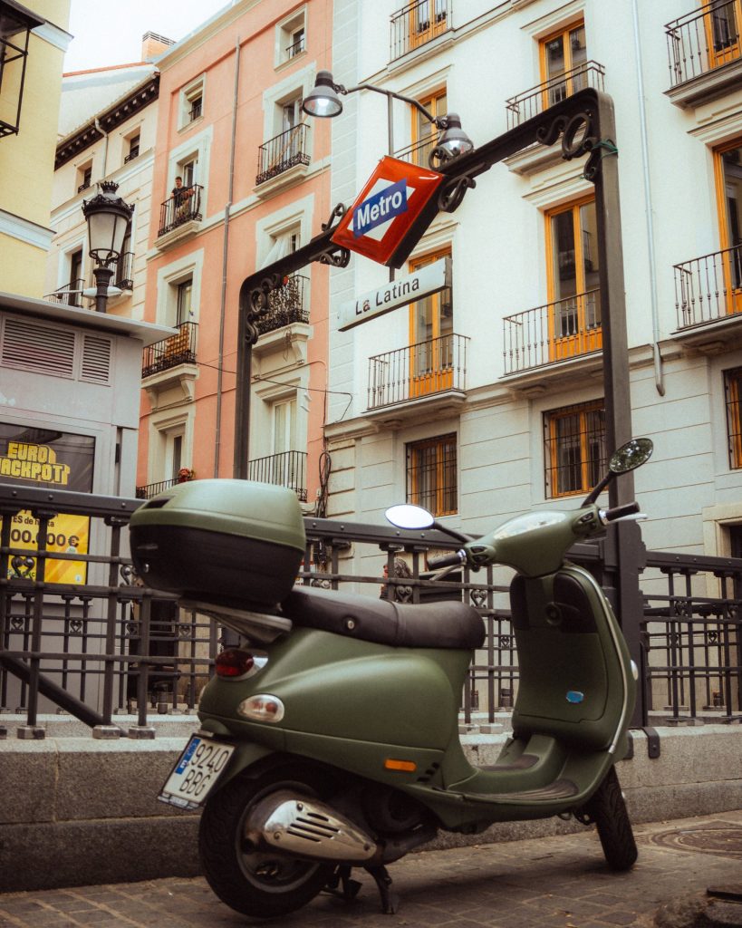 A scooter parked on a sloping street in La Latina