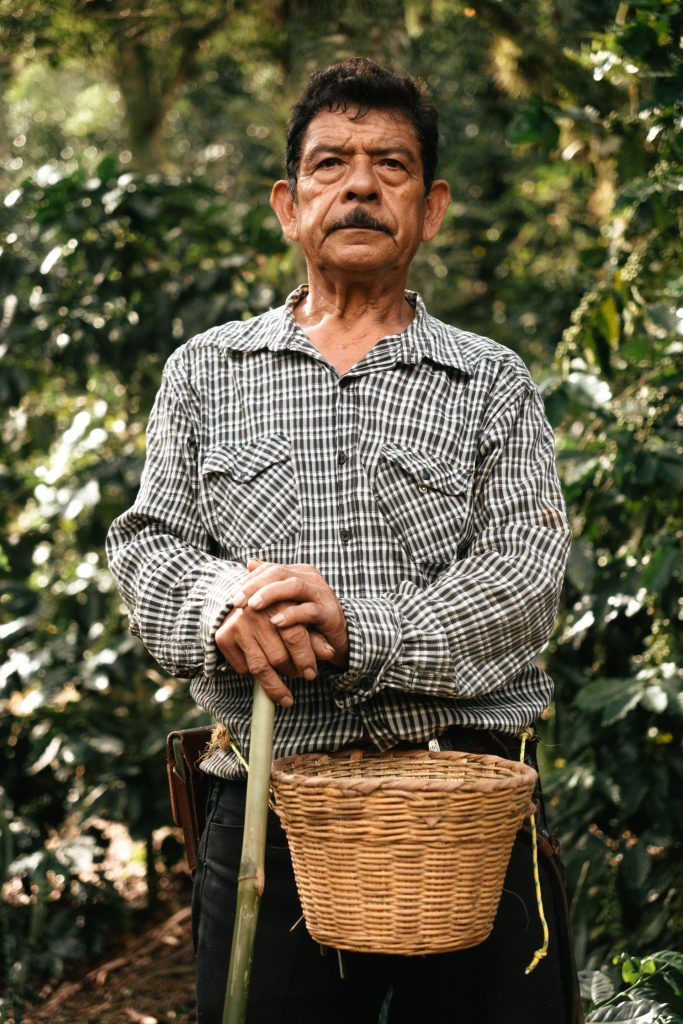 Portrait of a Colombian coffee farmer with a harvest basket at his waist