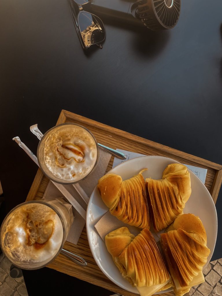 Two coffees and a plate of pastries on a tray