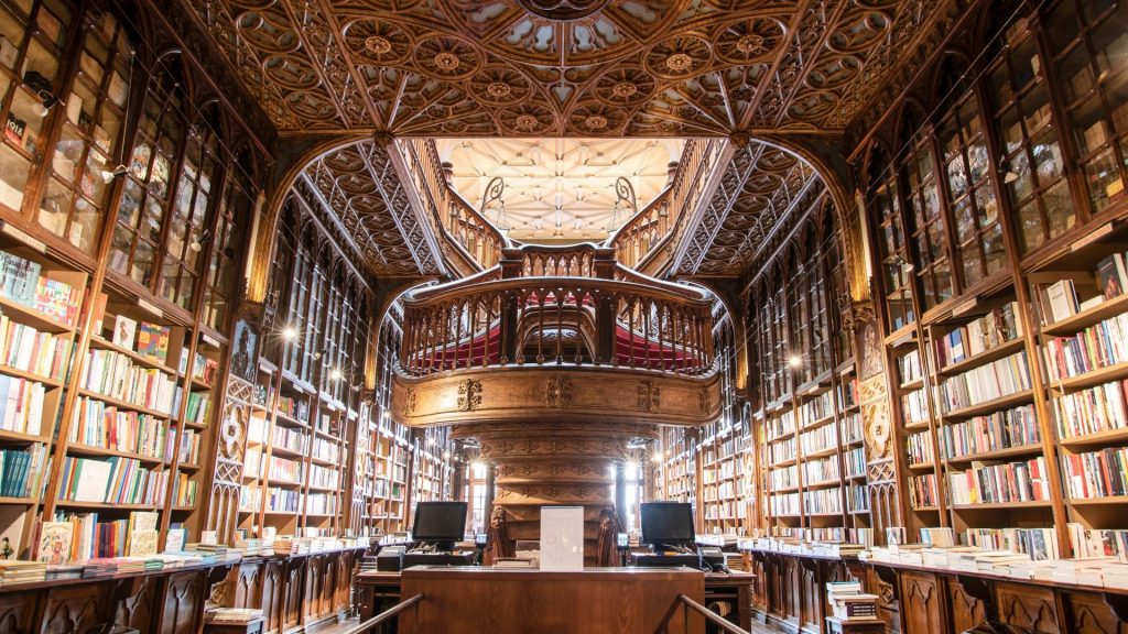 The carved wooden staircase and shelves inside Livraria Lello