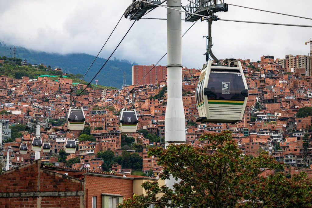 Metrocable gondolas crossing above the terracotta rooftops of Medellín