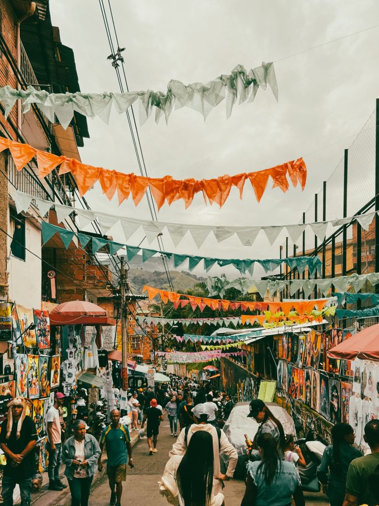 Busy Medellín market street hung with orange and white bunting