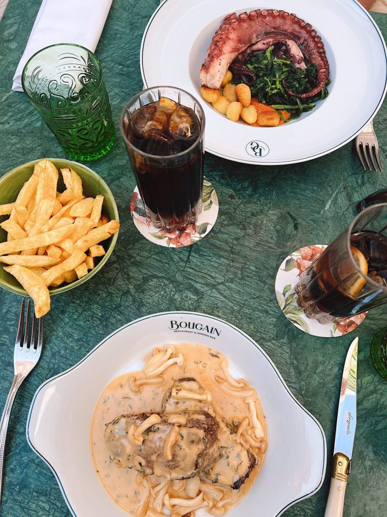 A table of octopus, chips and a creamy dish seen from above