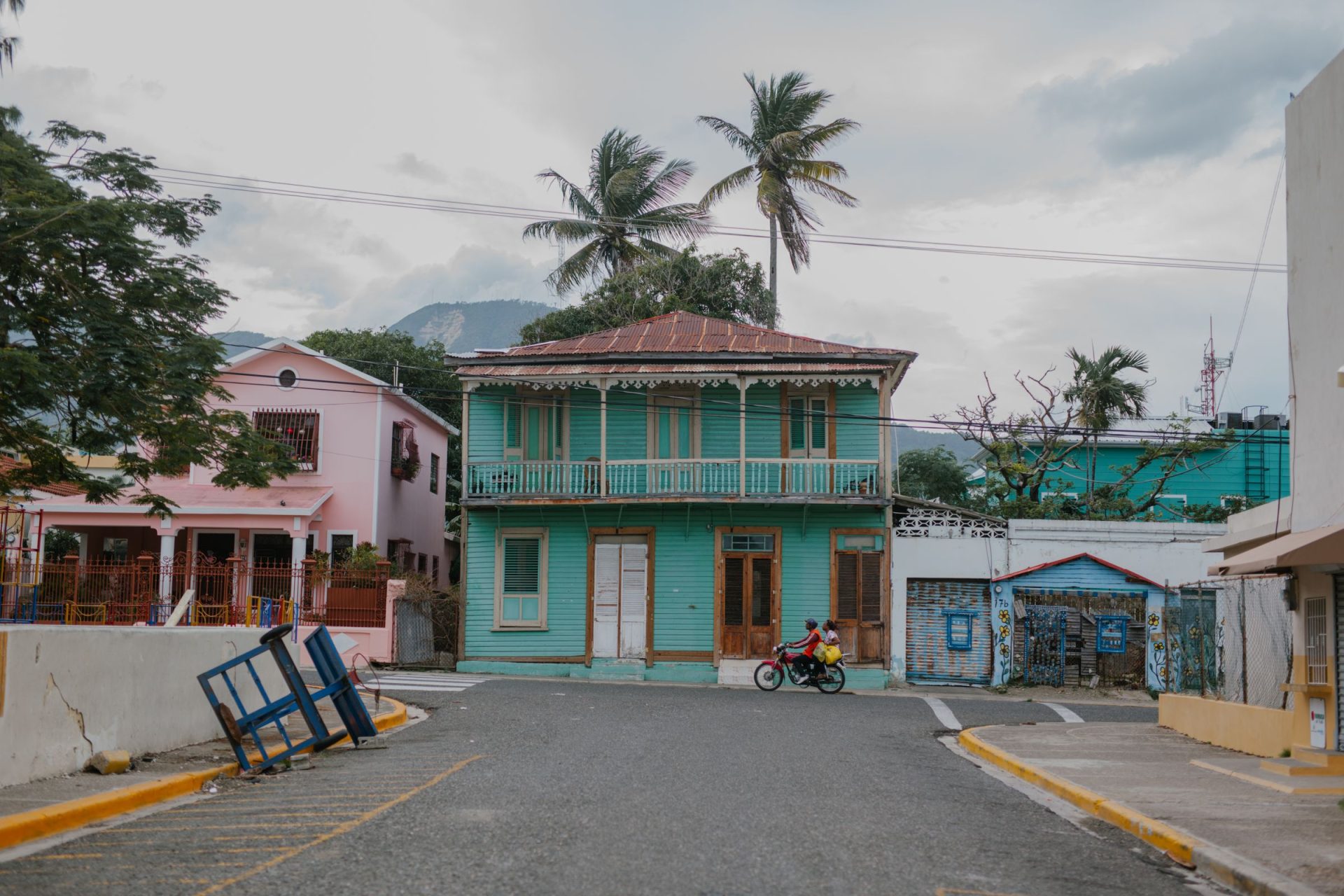 A Caribbean street of brightly painted houses under palm trees