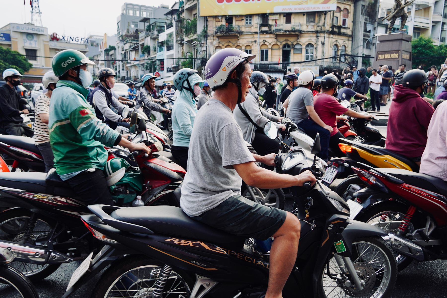 A dense stream of scooters crossing a Ho Chi Minh City street