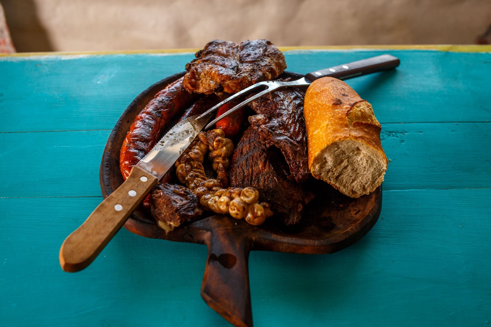 Assorted grilled meats with bread on a rustic wooden board