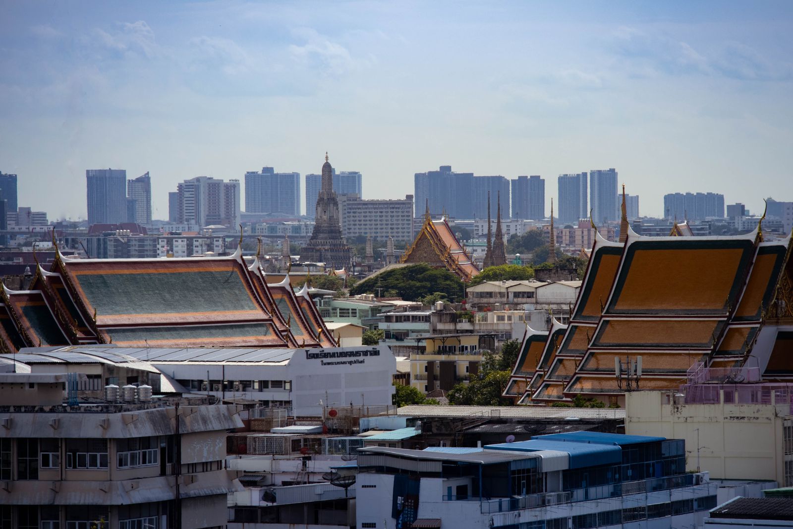 A temple roof in the foreground with the Bangkok skyline behind it