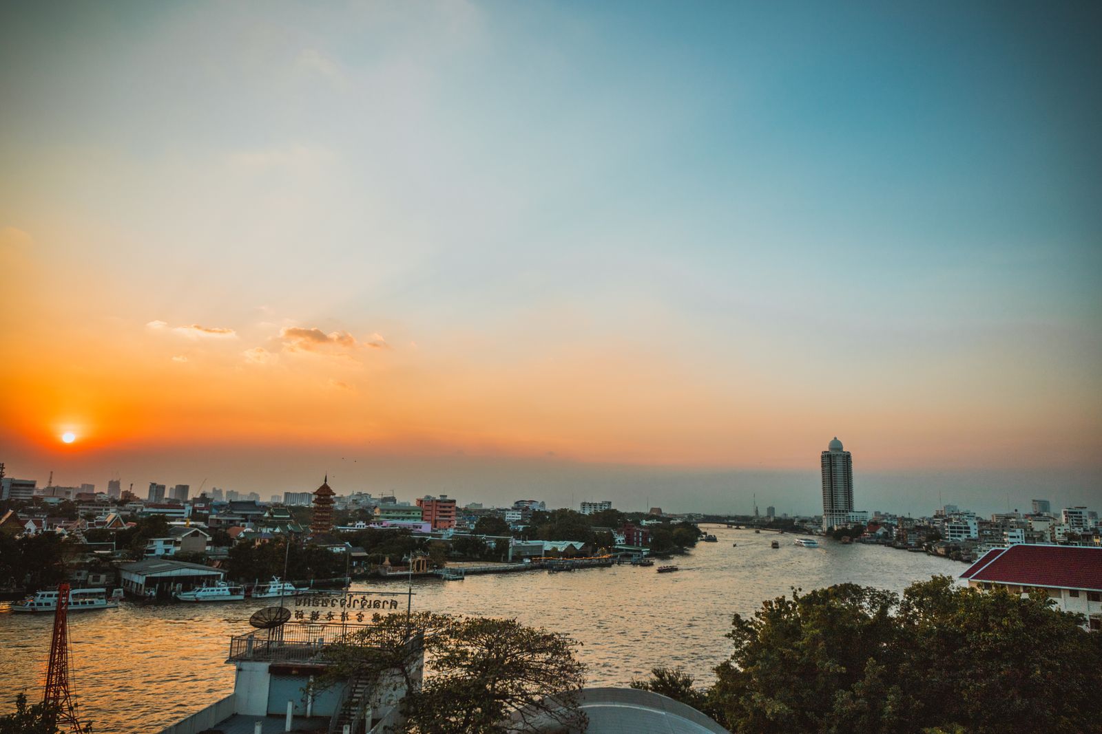 Sunset over Bangkok's Chao Phraya River and city skyline