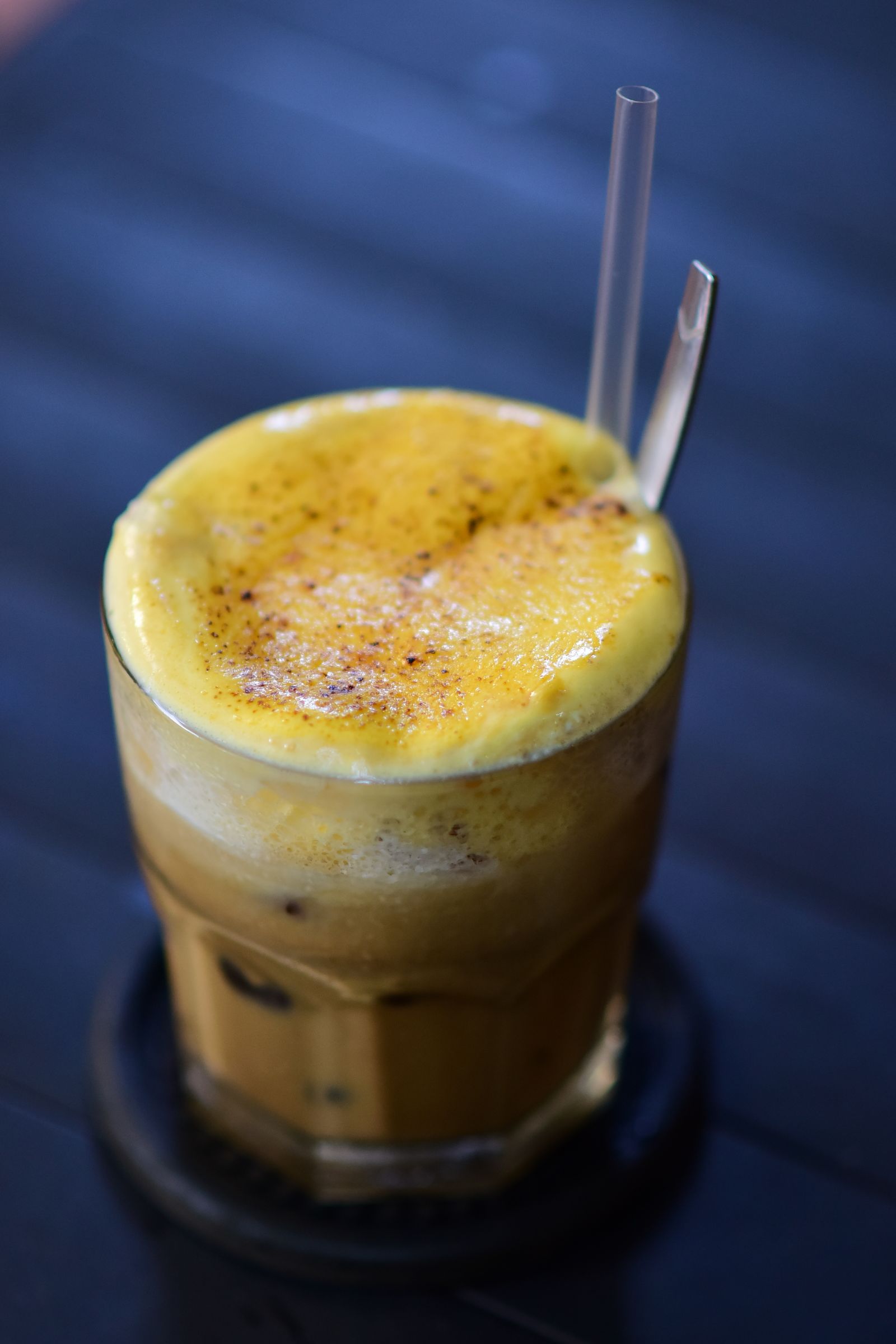 A creamy Vietnamese egg coffee topped with frothy foam in a glass