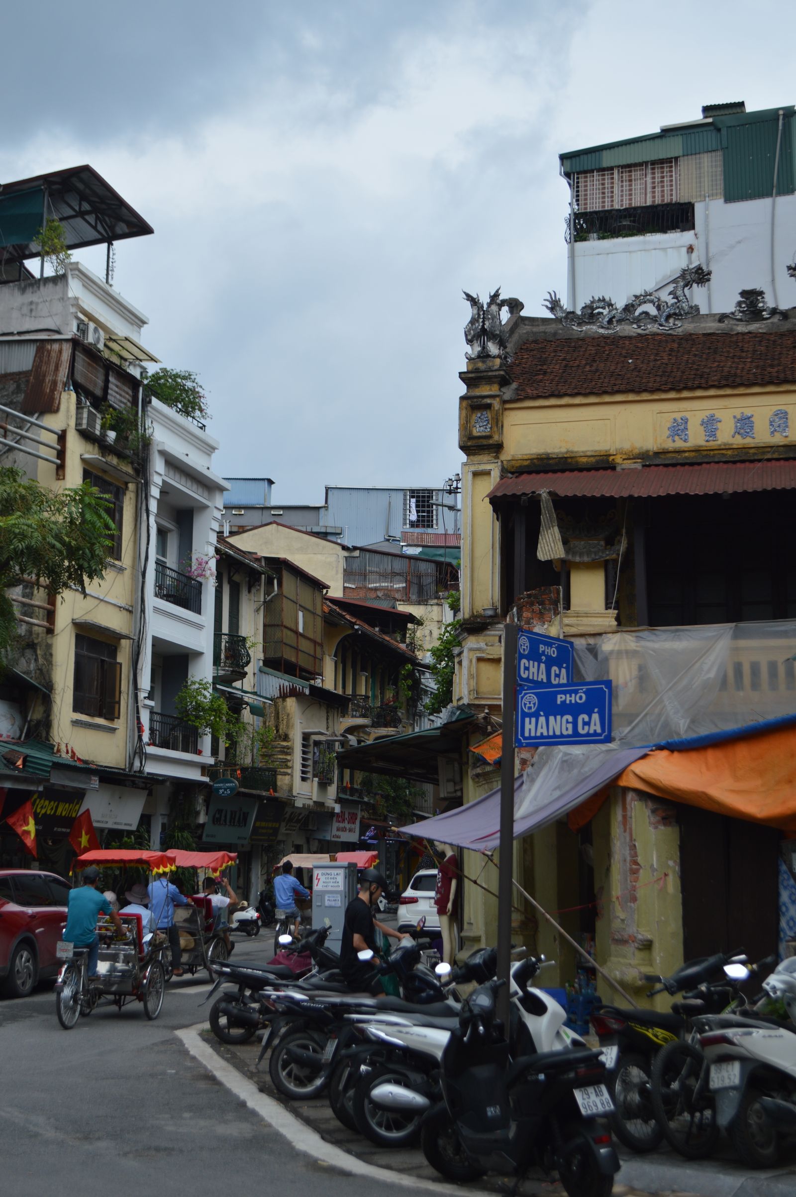 Hanoi Old Quarter filled with scooters and traditional shophouse architecture