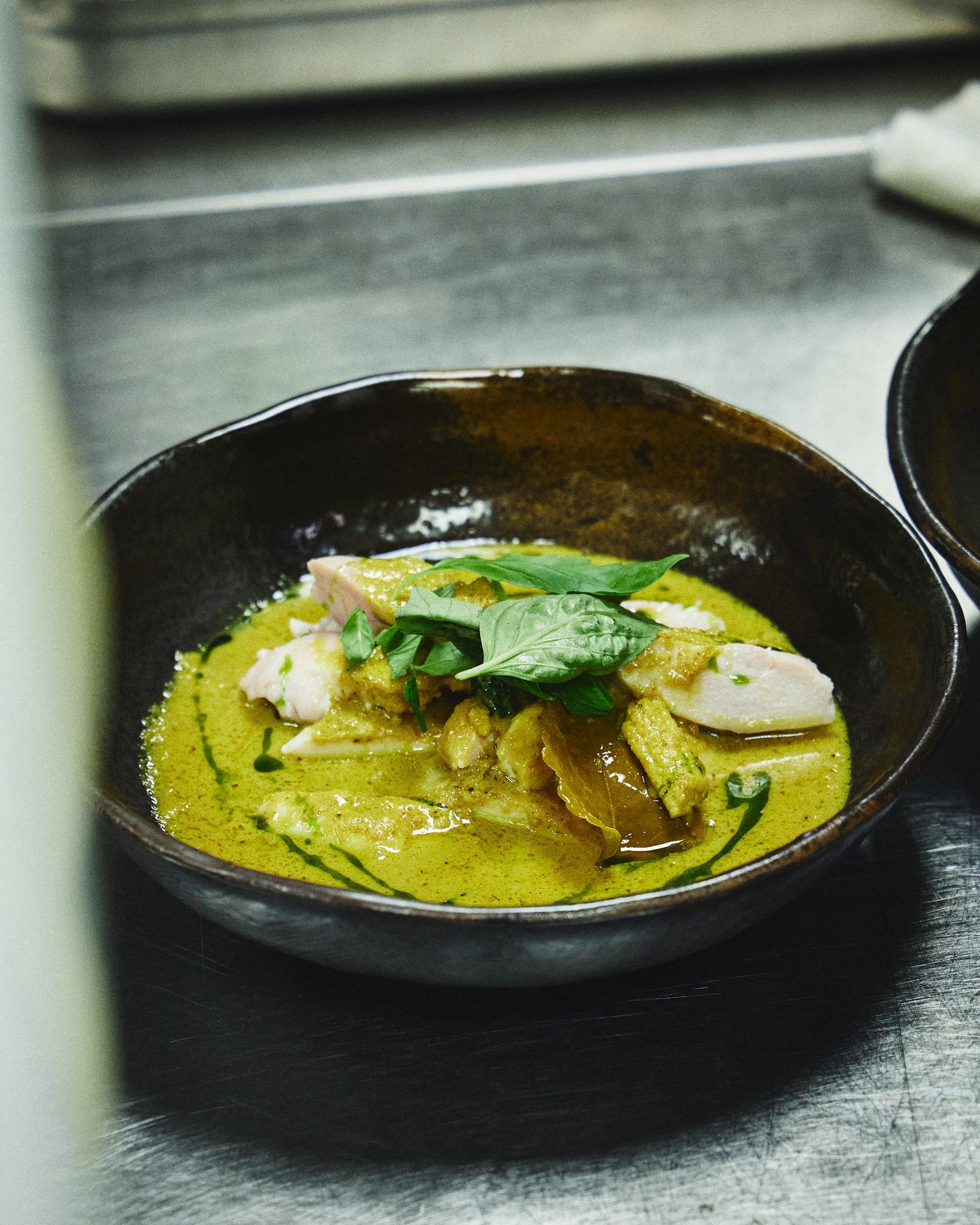 Thai green curry with chicken, garnished with fresh basil