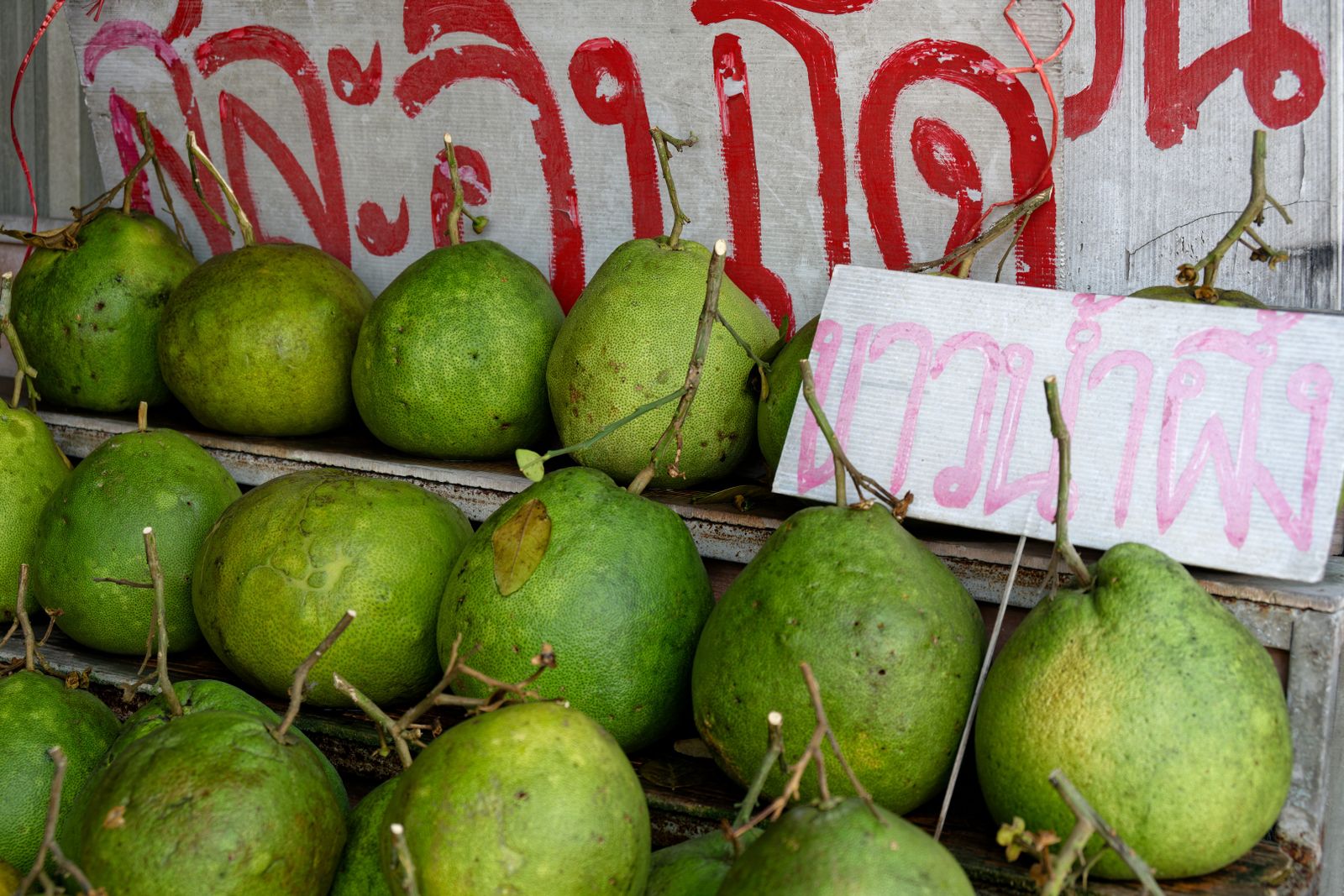 Tropical pomelos stacked at a market stall in Thailand