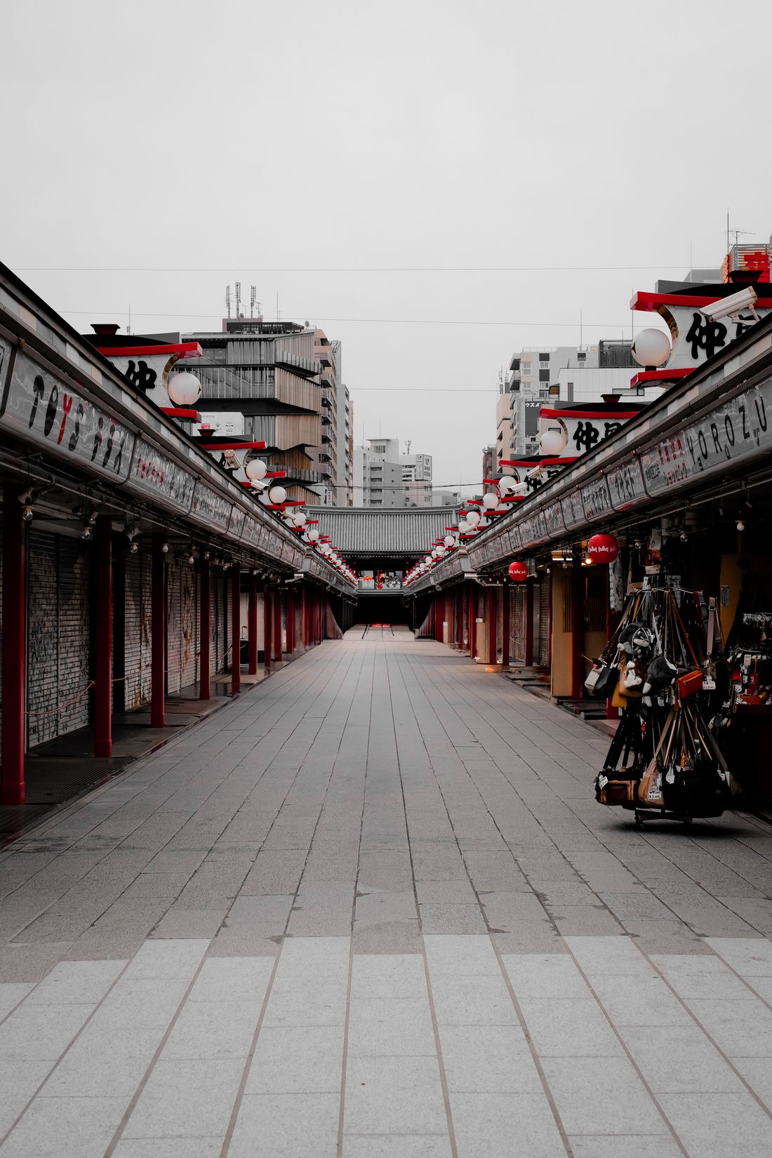 A wide Tokyo shopping street lined with low shopfronts and lanterns