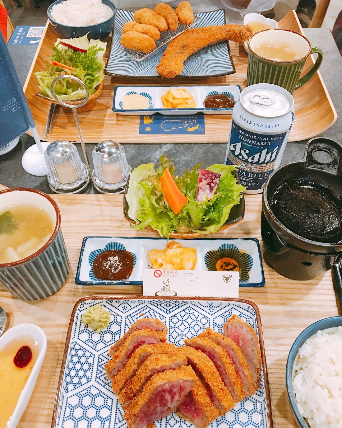 A Japanese set meal of breaded pork cutlet with rice, miso and pickles on a light table