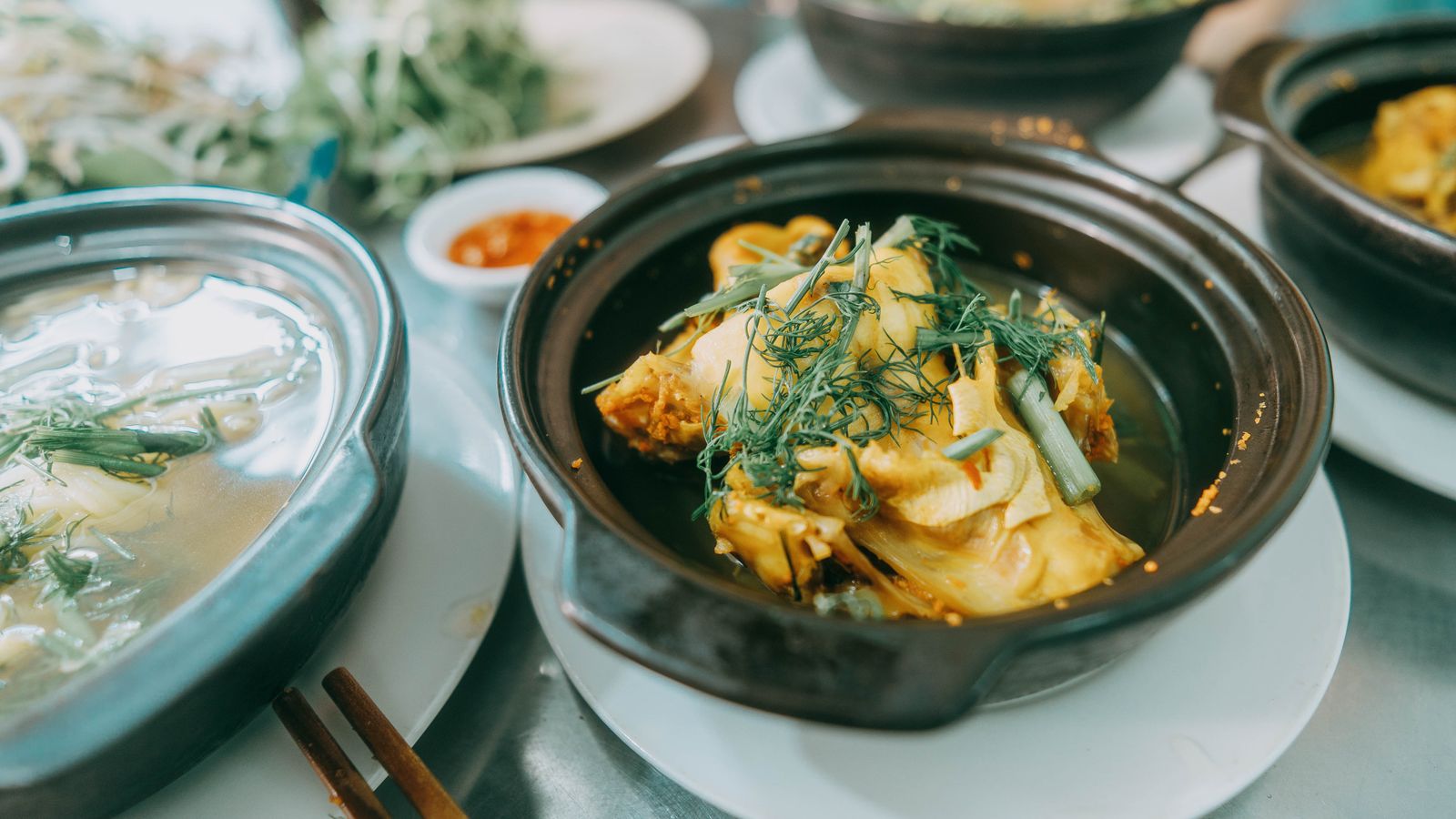 Traditional Vietnamese fish cooked with herbs in a clay pot