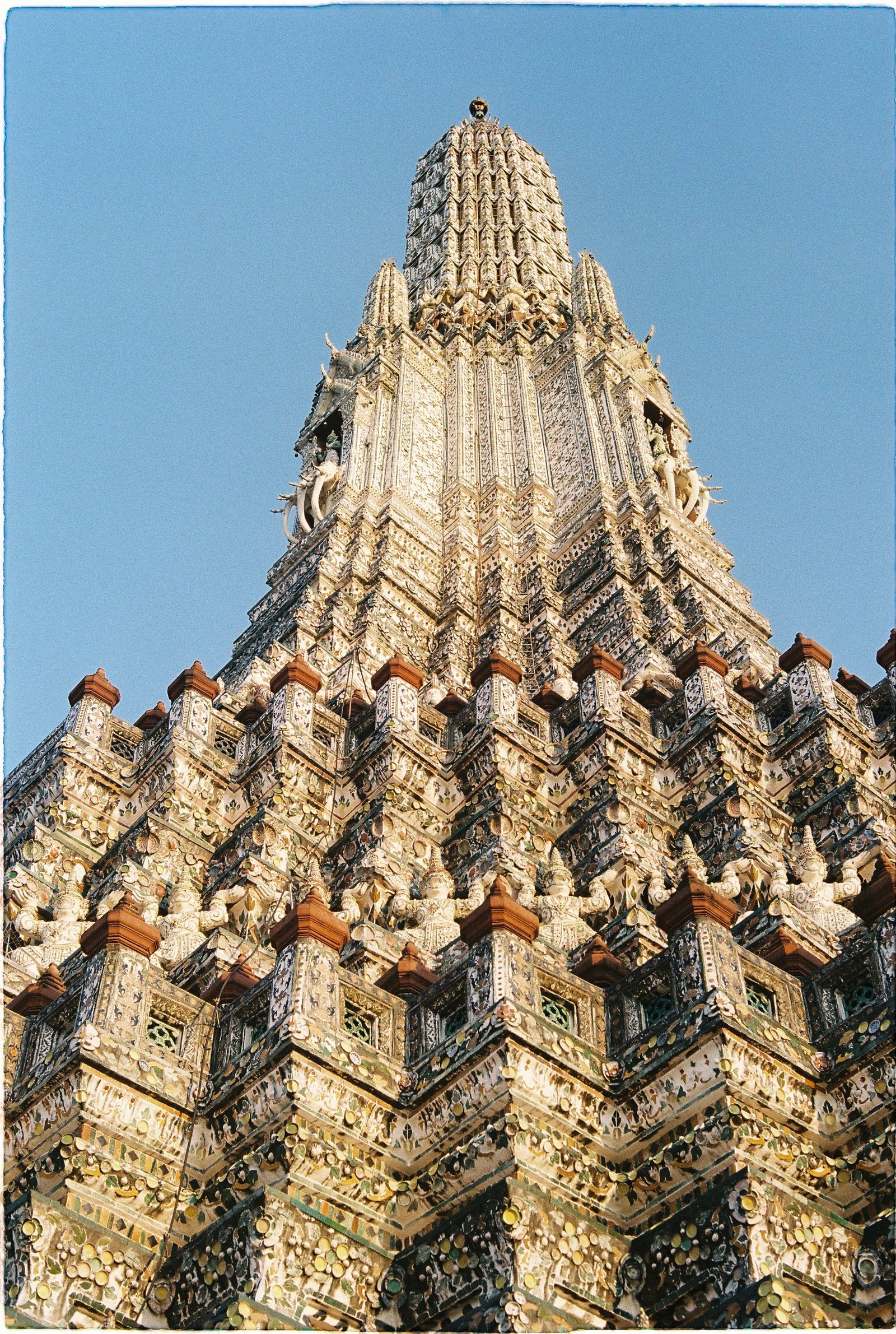 The ornate spire of Wat Arun under a clear Bangkok sky