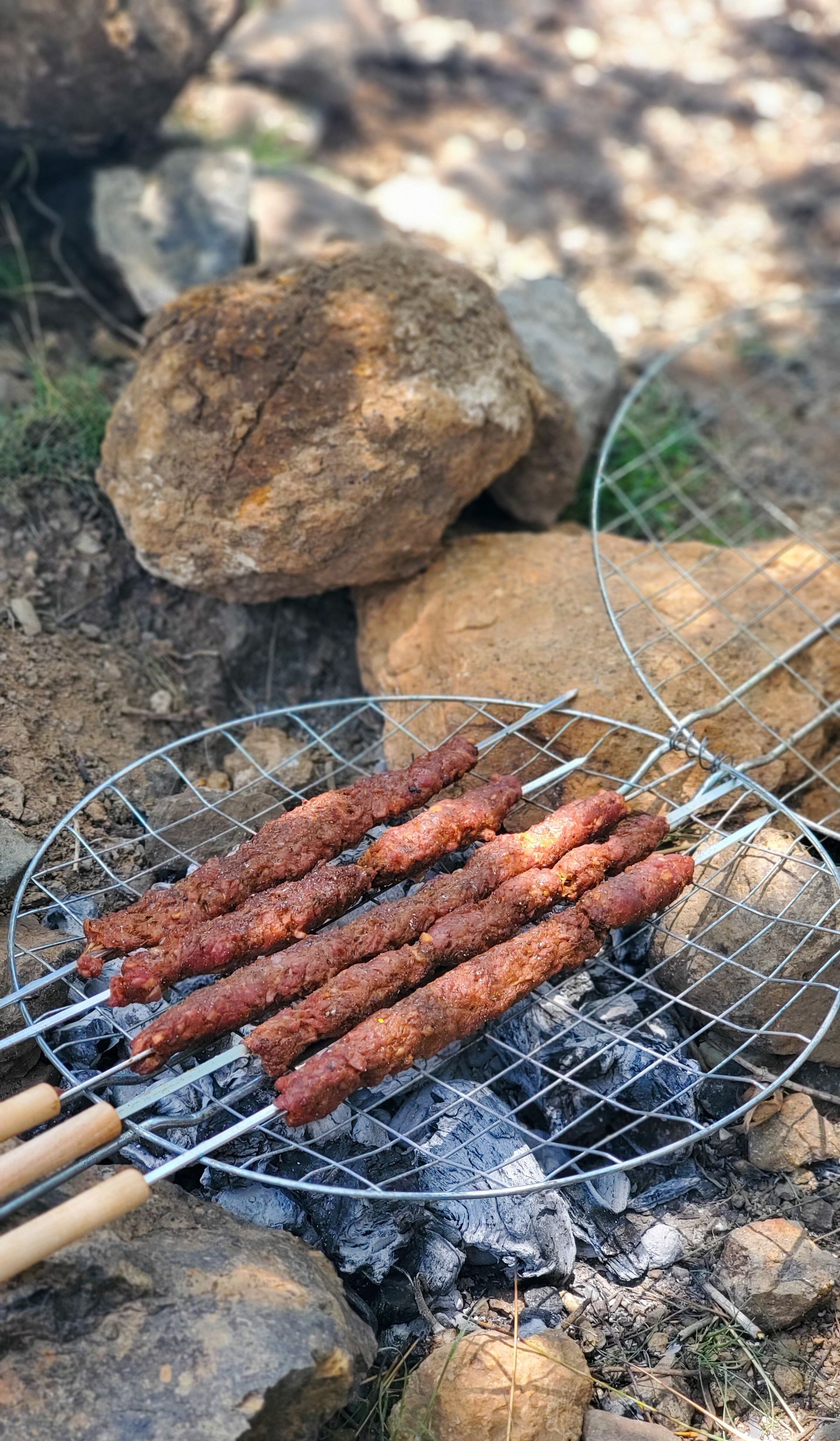 Marinated meat skewers grilling over charcoal