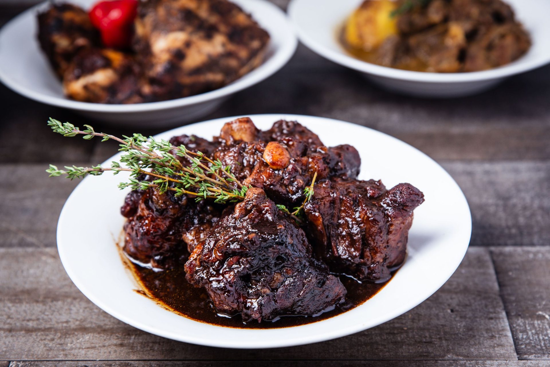 Braised oxtail in a rich sauce, served with herbs