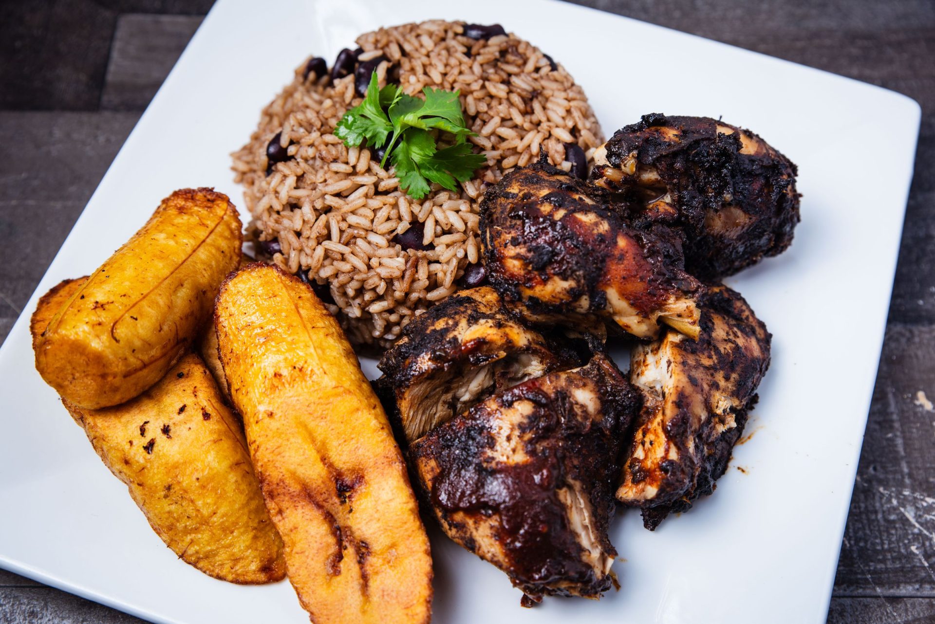 Caribbean jerk chicken served with rice and beans and fried plantains