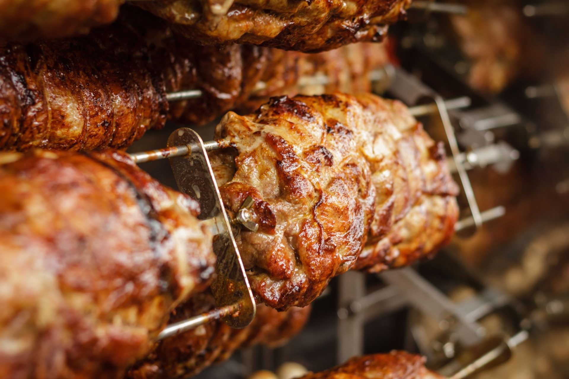 Whole pork roasting on a rotisserie spit until the skin crackles