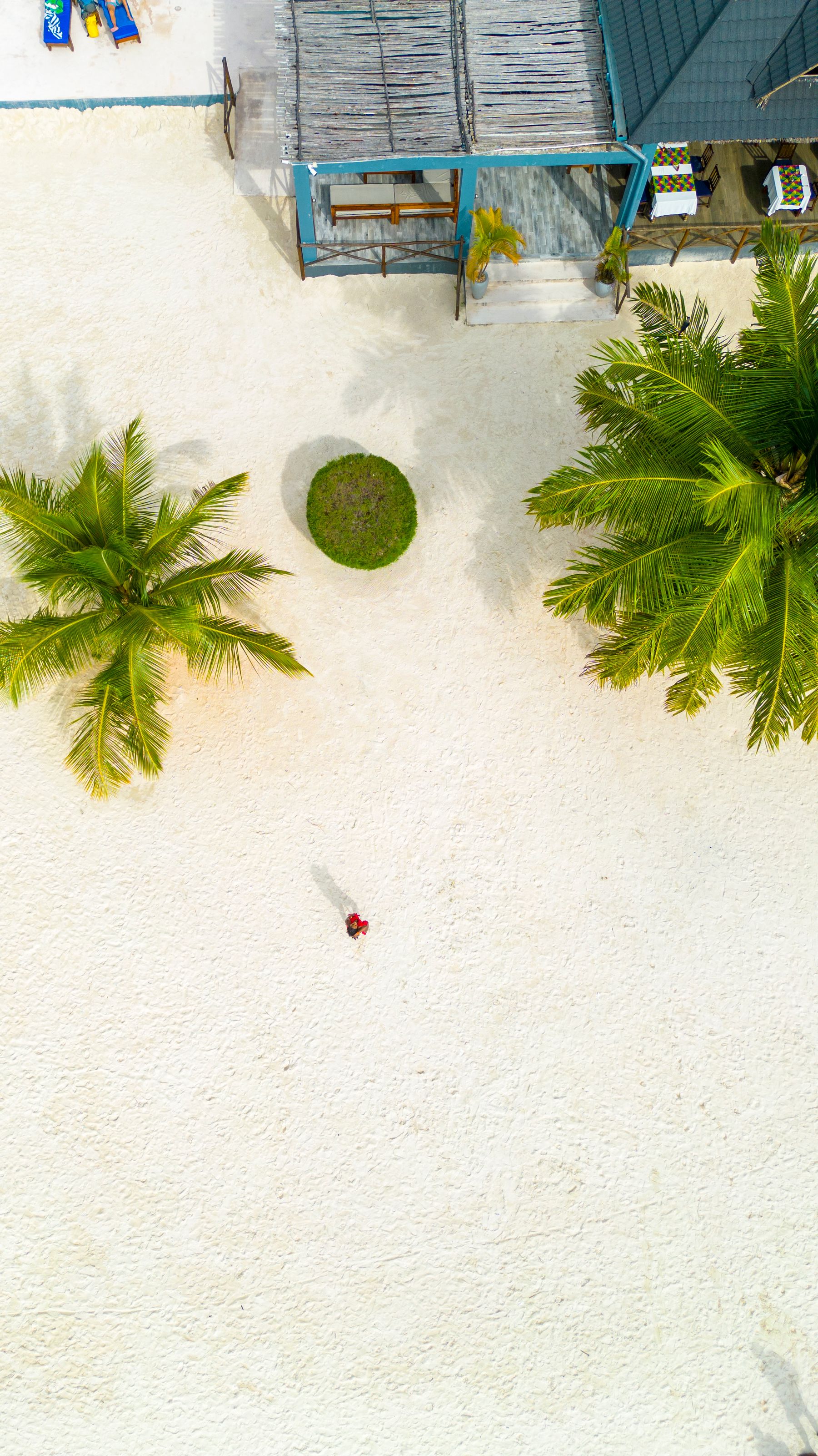 Aerial view of a turquoise sea meeting a pale sand beach