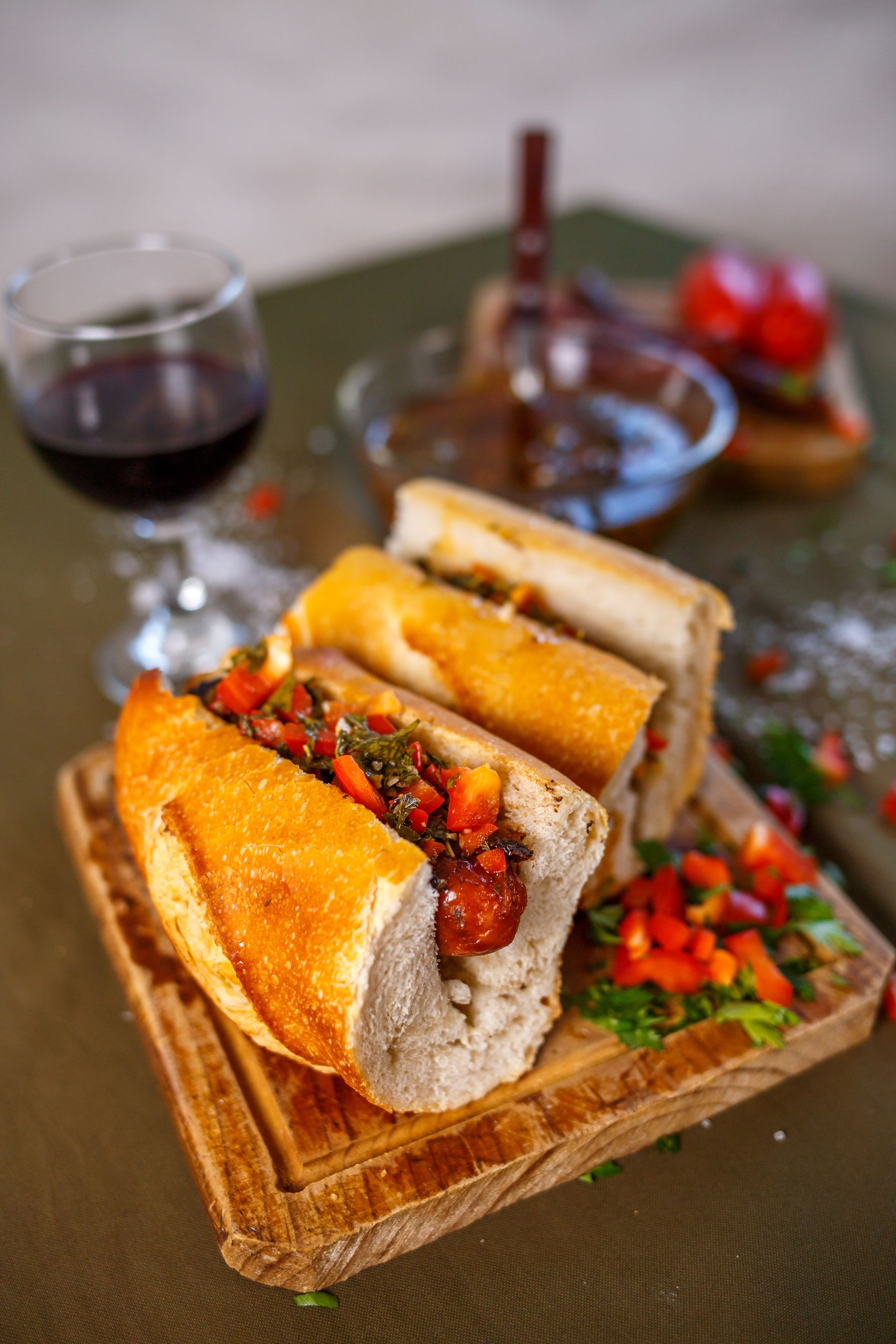 An Argentine choripan with chimichurri sauce and a glass of red wine