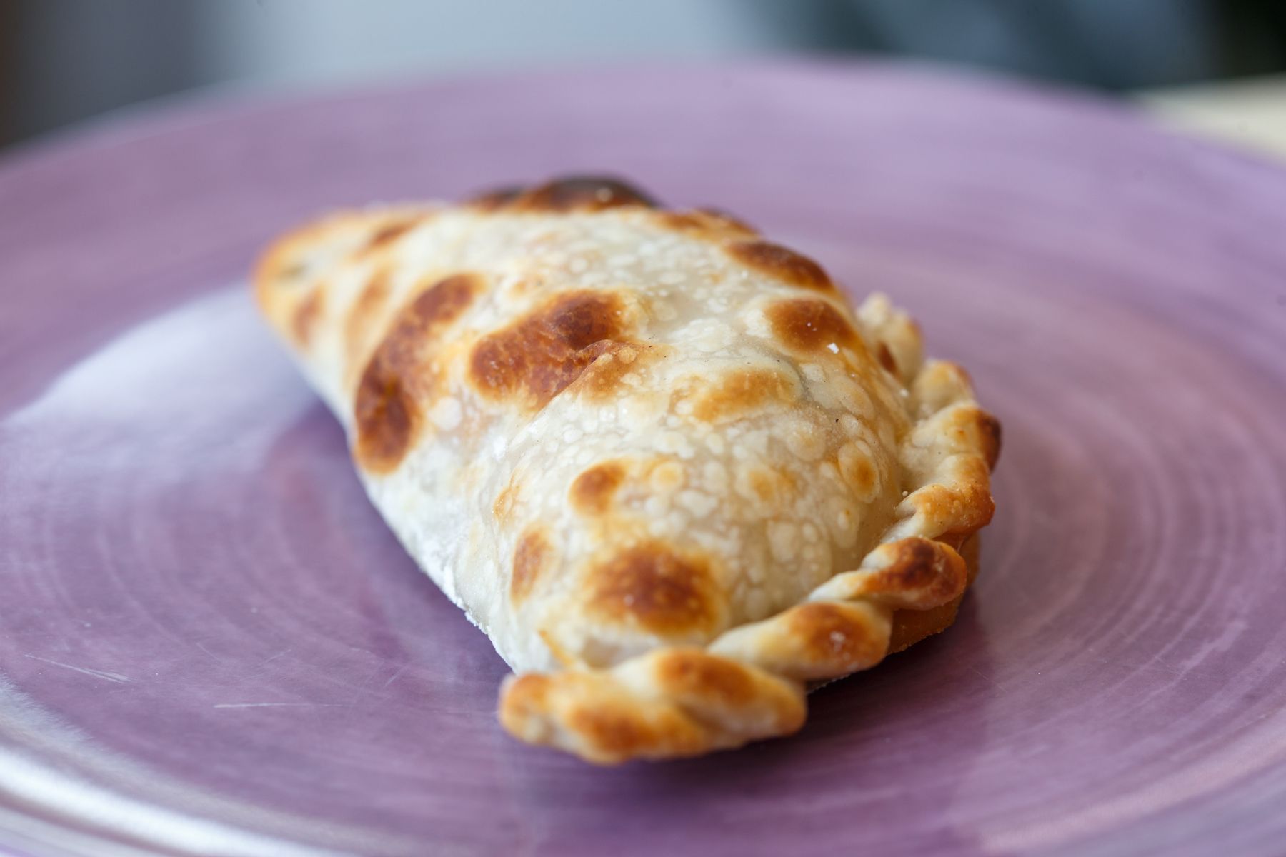 A freshly baked Argentine empanada on a plate