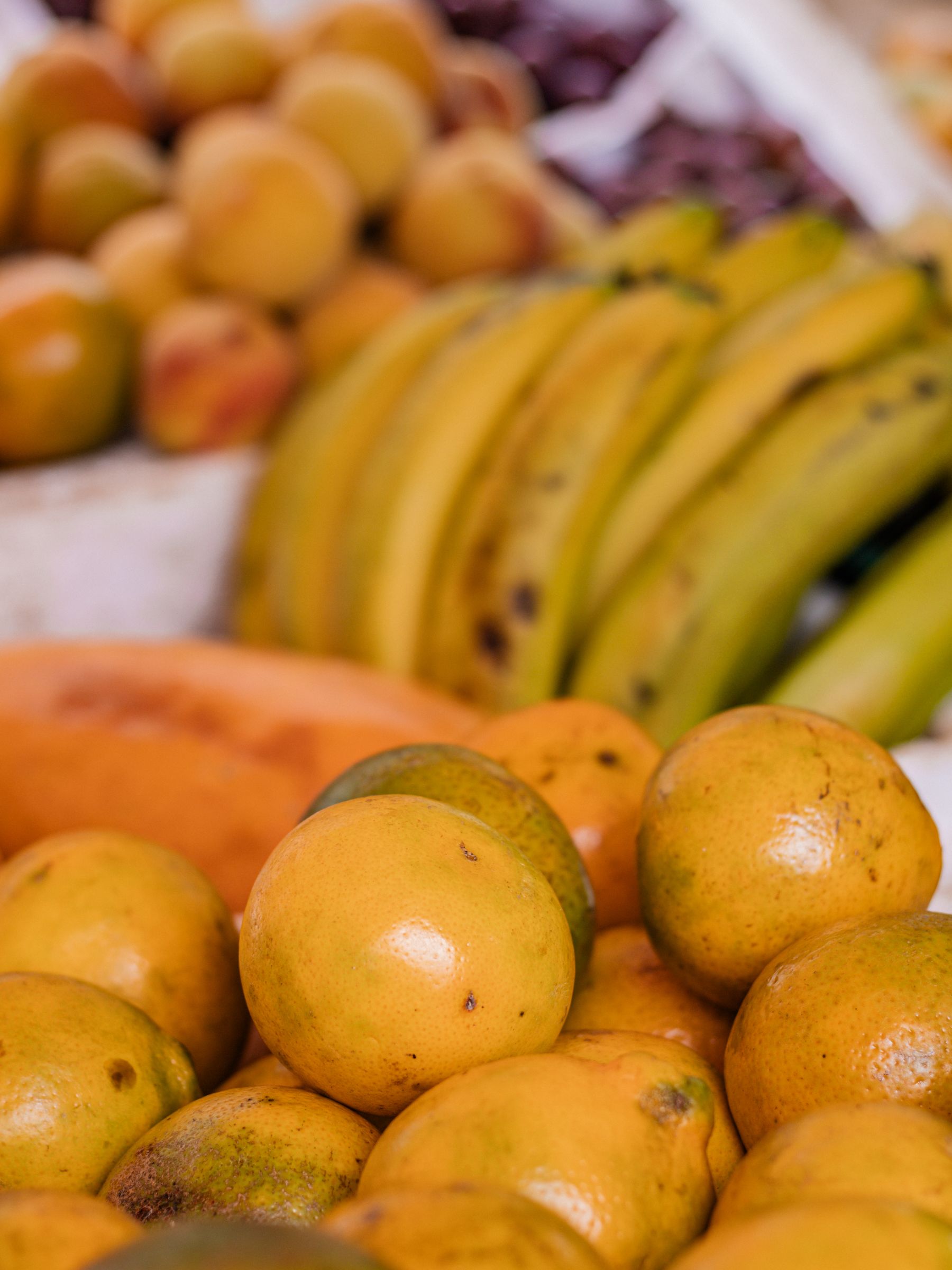 A market stall stacked with tropical fruit including mango and papaya