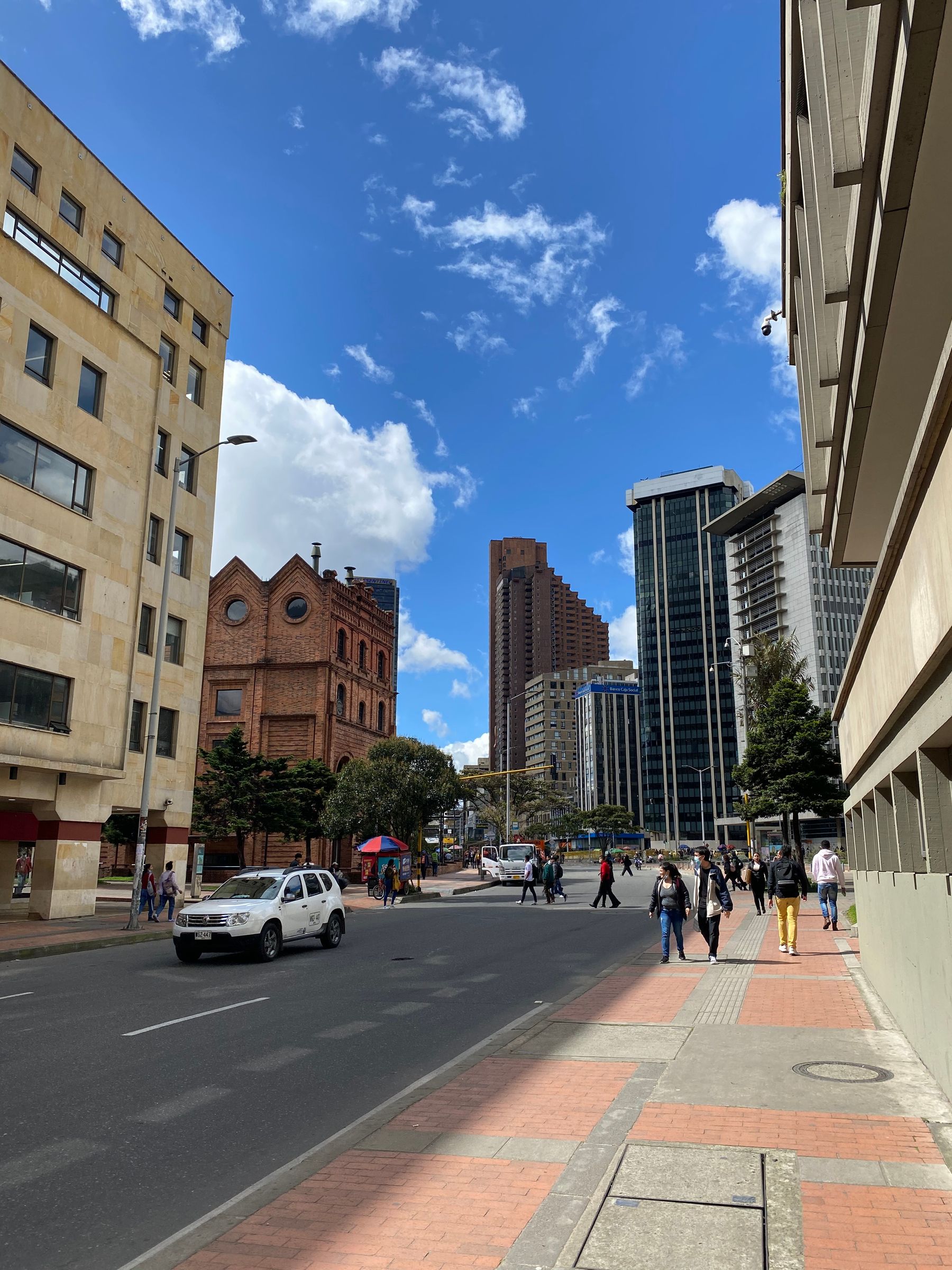 Bogota city street with pedestrians below modern towers