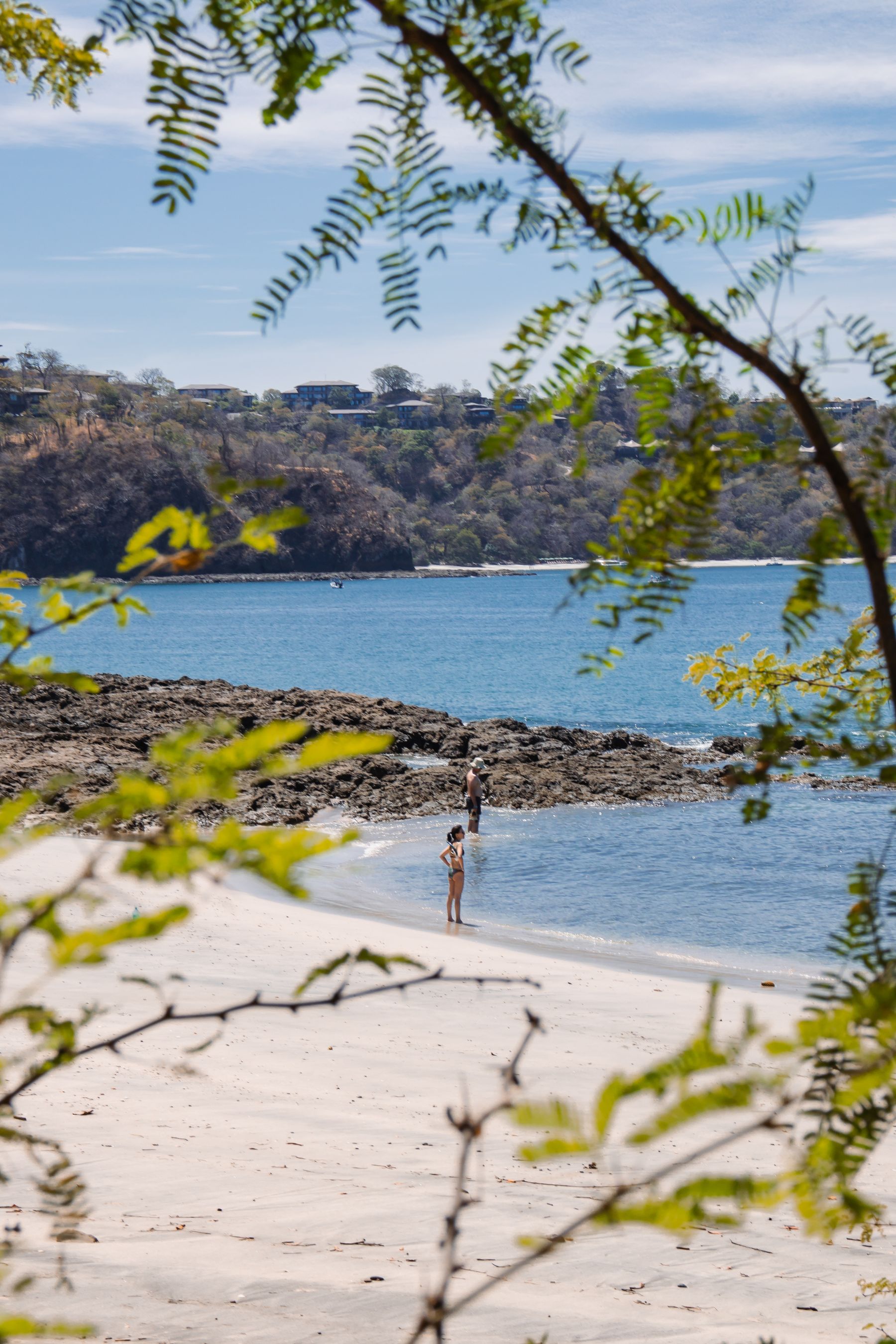 People enjoying the sun and waves on a beach in Costa Rica