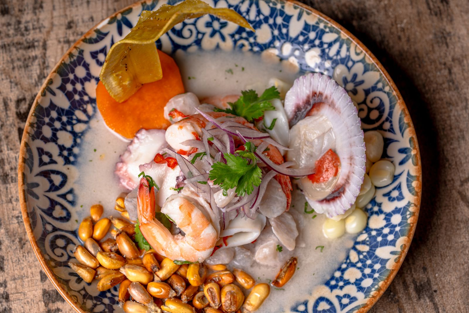 Close-up of Peruvian ceviche with seafood, corn and garnishes