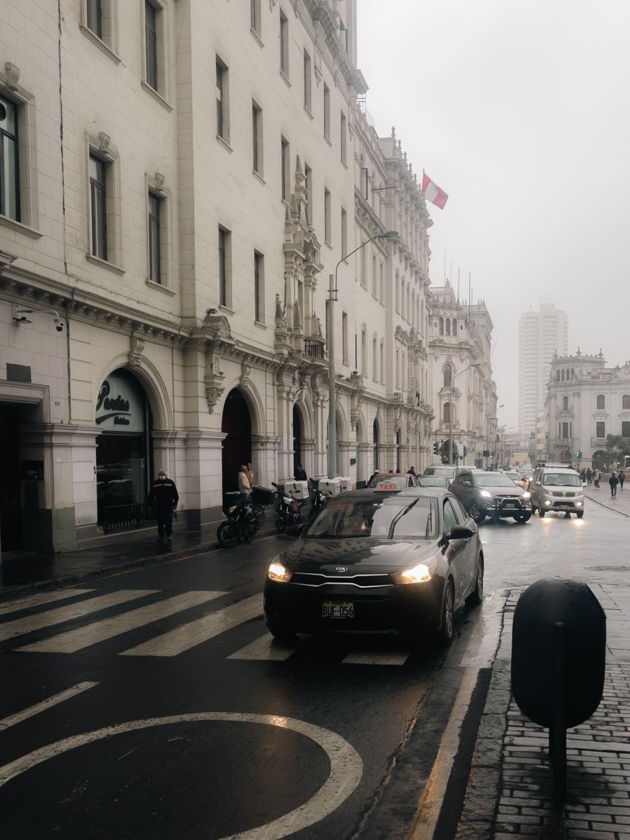 Traffic and pedestrians on a wet street in Lima’s historic centre