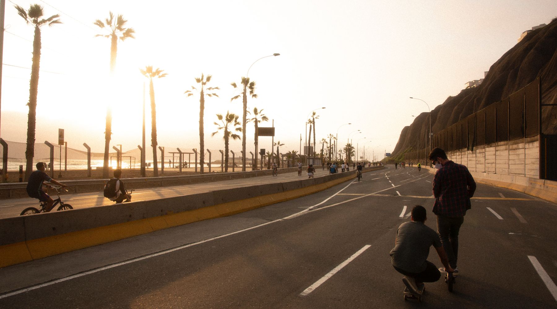 Lima food guide: cyclists and skateboarders on the Pacific coastal road at sunset