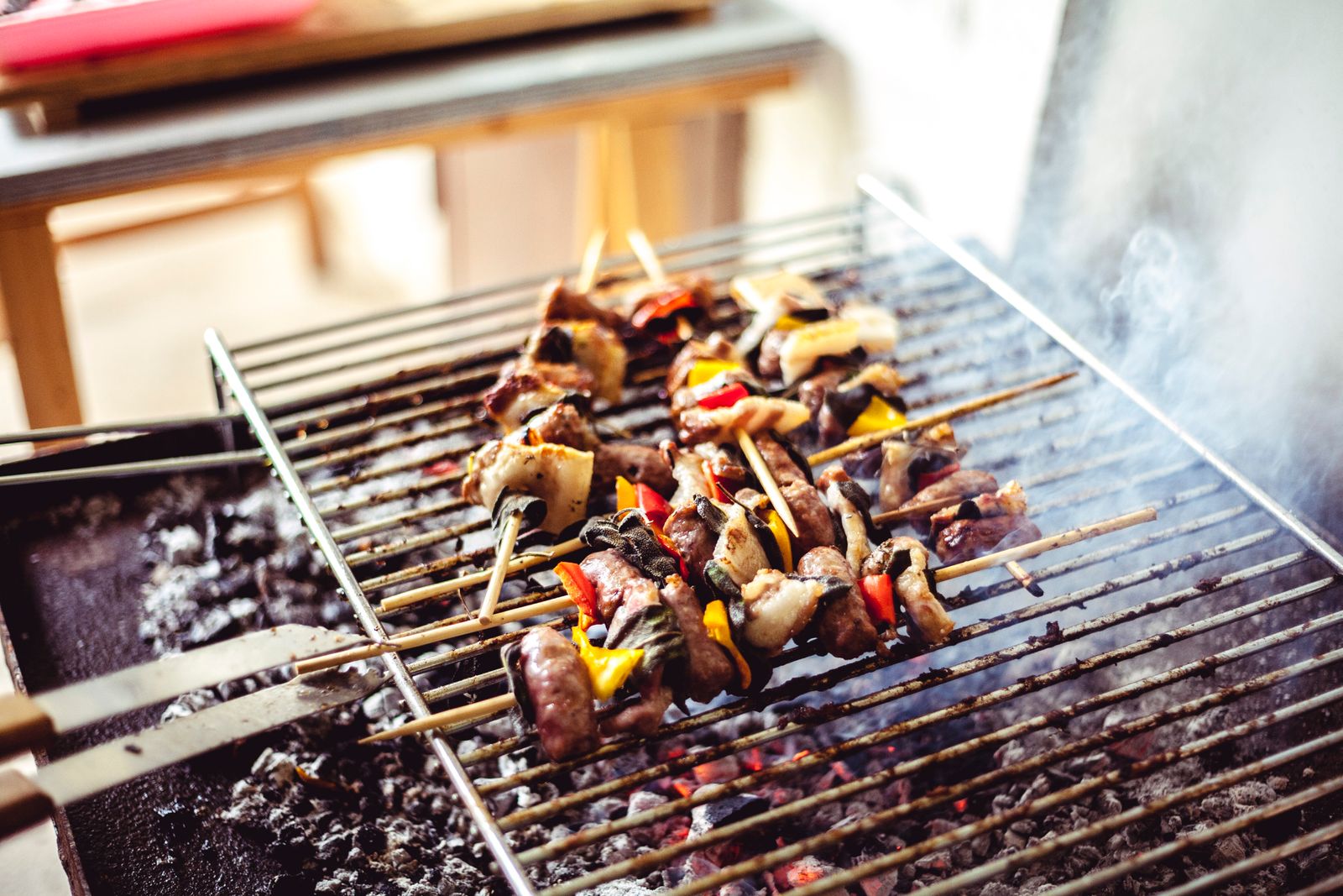 Marinated meat skewers grilling over hot charcoal at a street stall