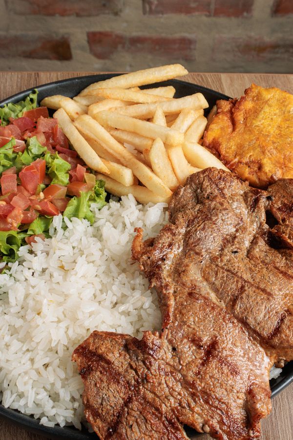 Bandeja paisa with grilled steak, rice and patacones