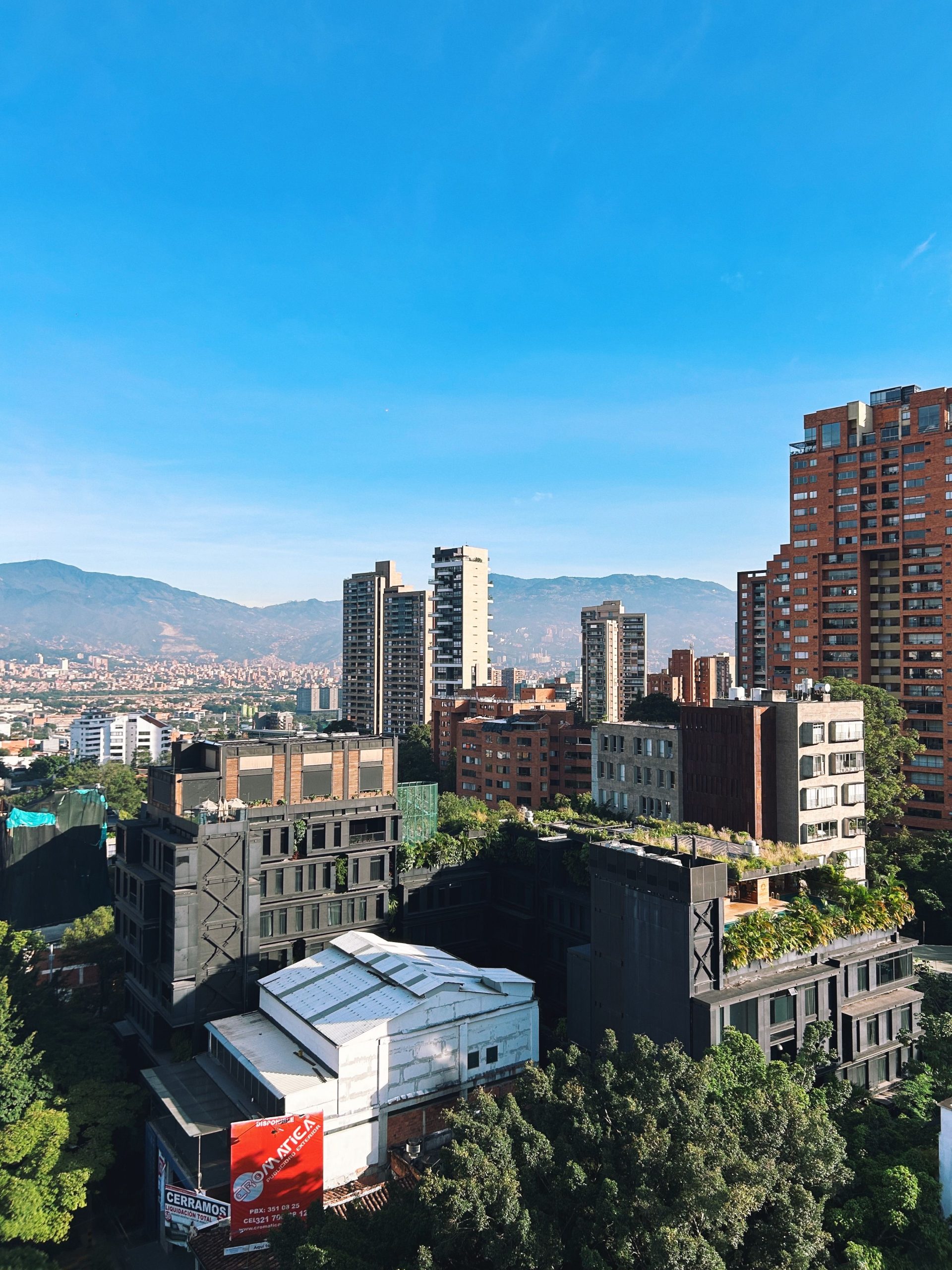 High-rise towers of El Poblado, Medellín, with the green hills of the valley behind