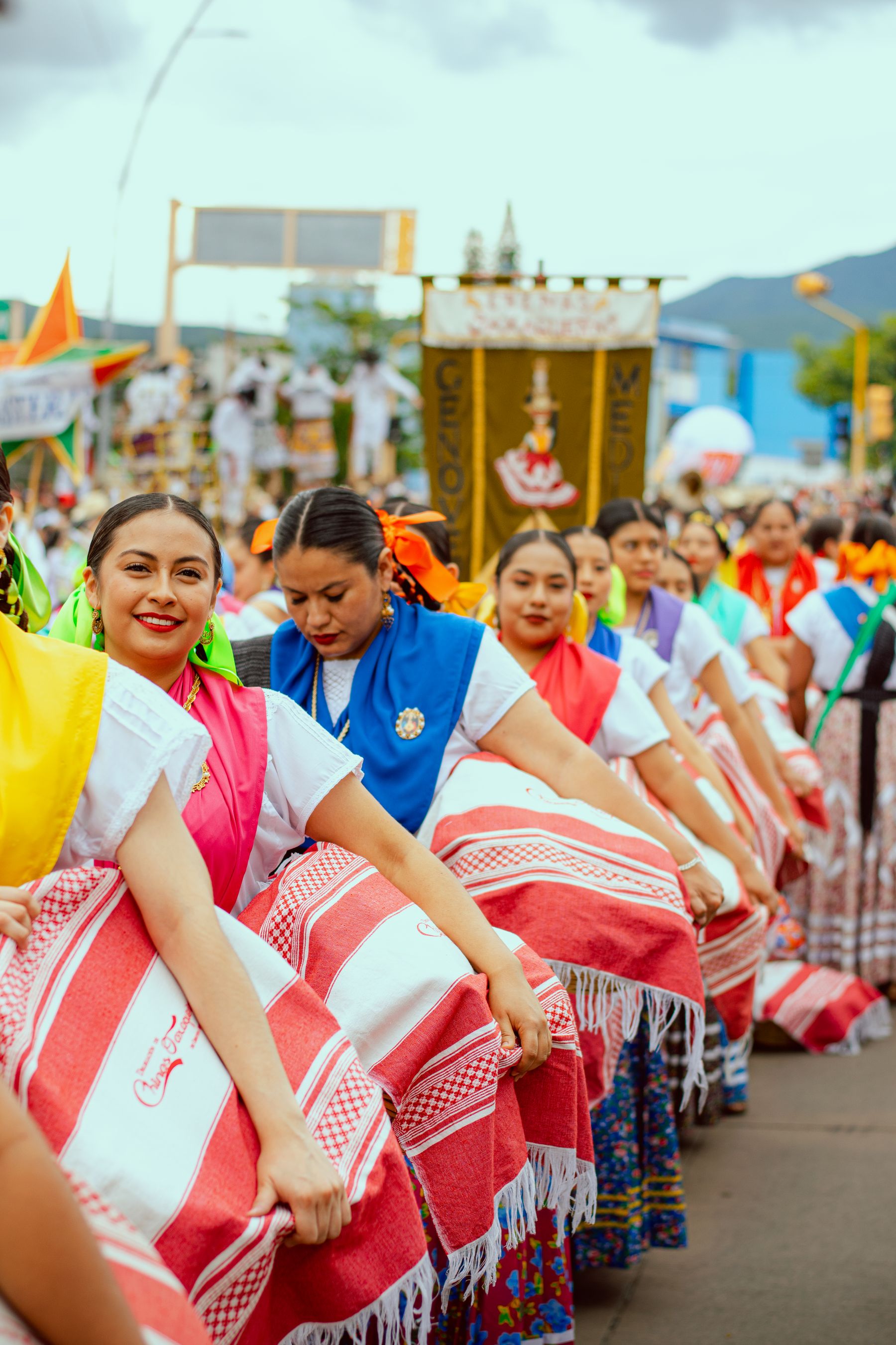 Women in festive traditional attire in a colourful parade in Oaxaca